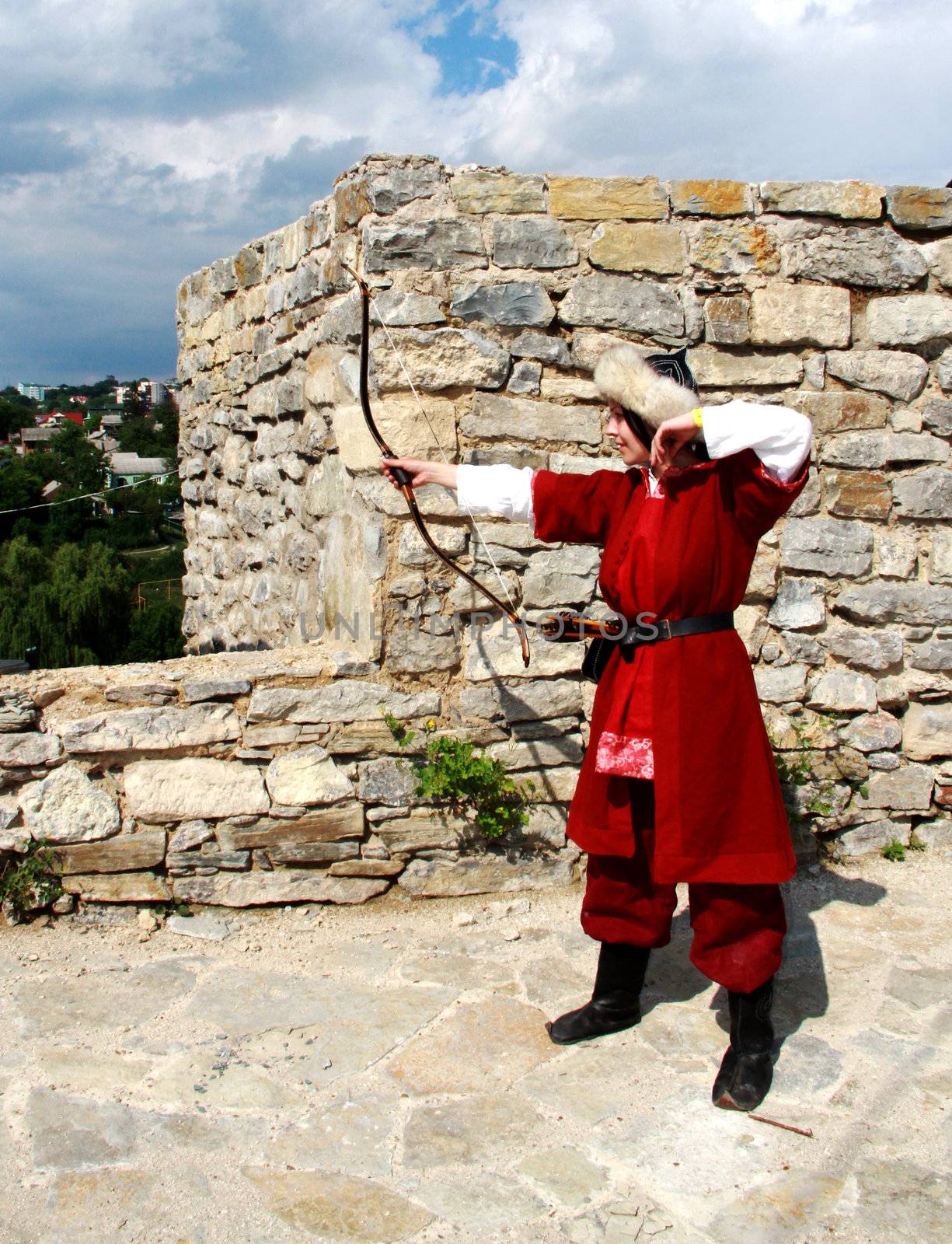 Beautiful young girl with bow and arrows in medieval costume