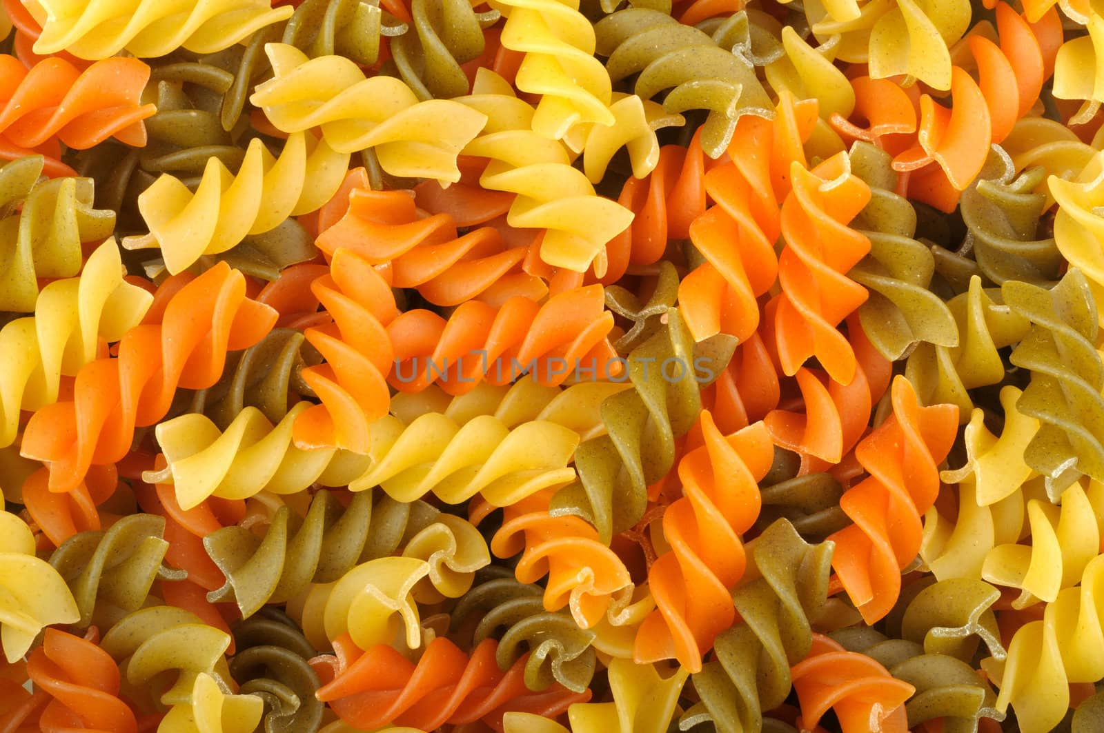 background of raw dry spiral Tricolor pasta