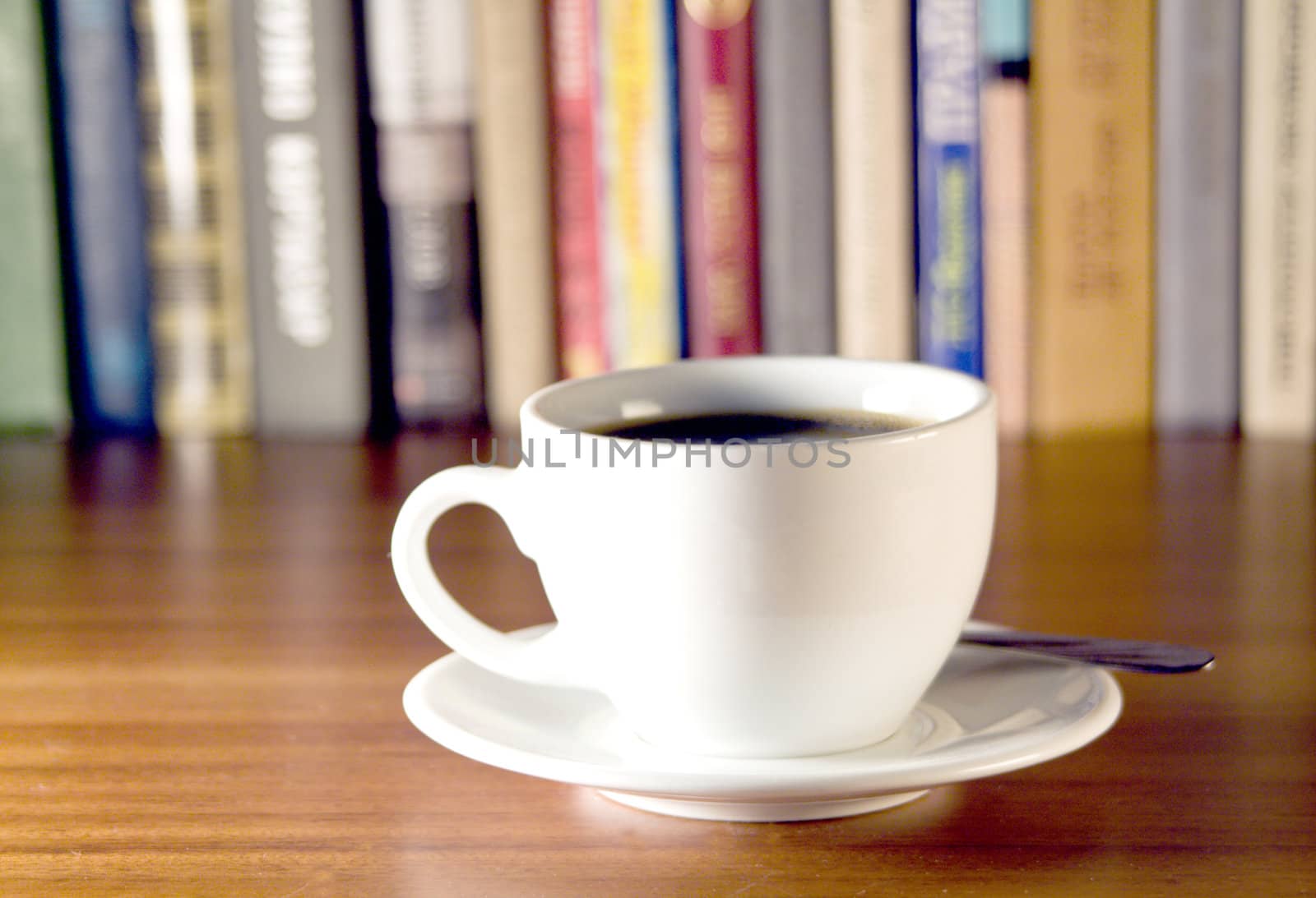Coffee and books on a wooden table. Small depth of sharpness.