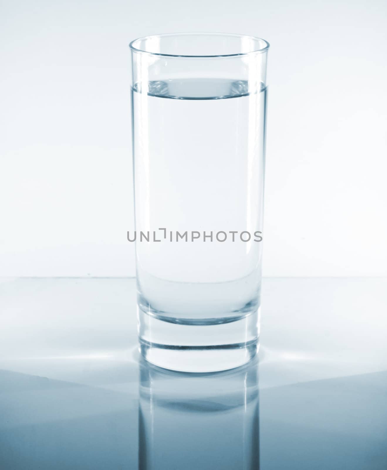 Glass of water on a reflective table top