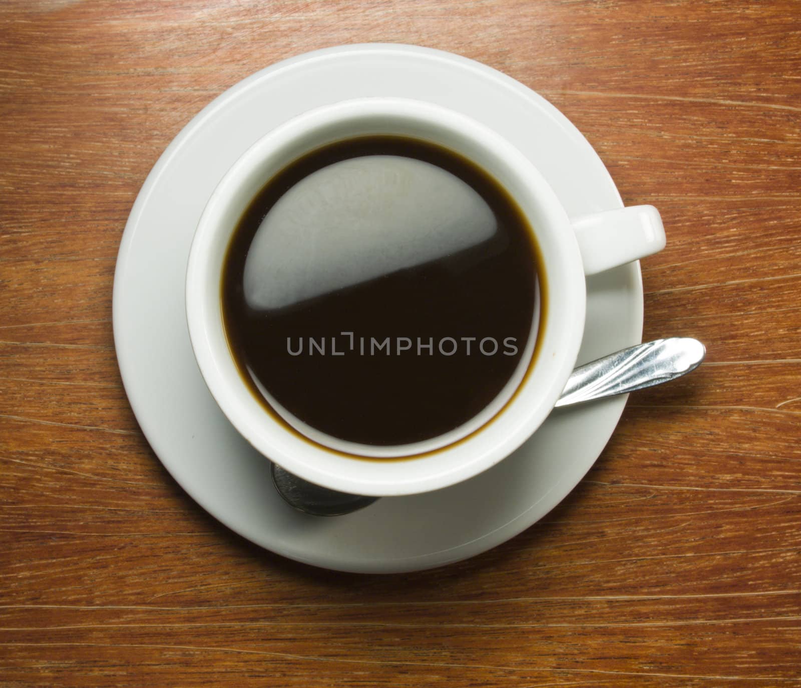 Coffeecup with Coffee in it on a wooden table by smoki