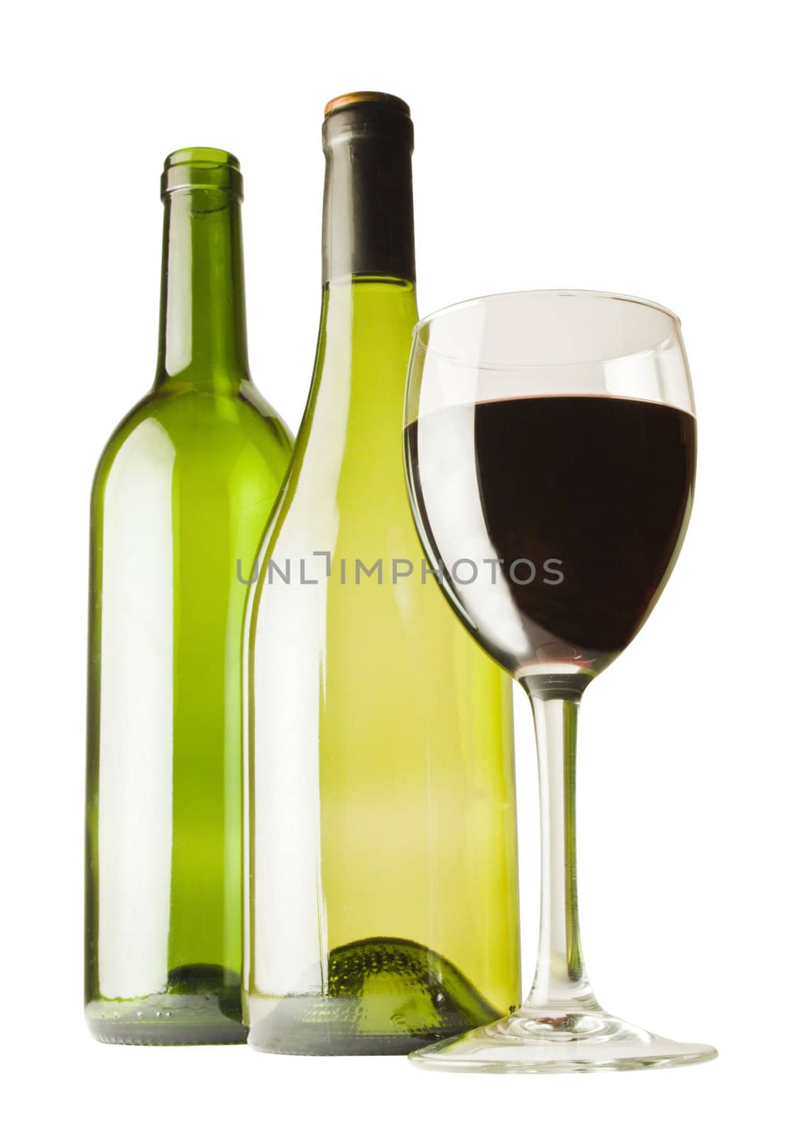 A glass of red wine with two wine bottles