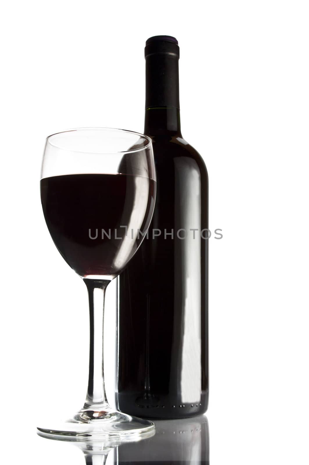 Bottle of red wine and glass. Studio shot.