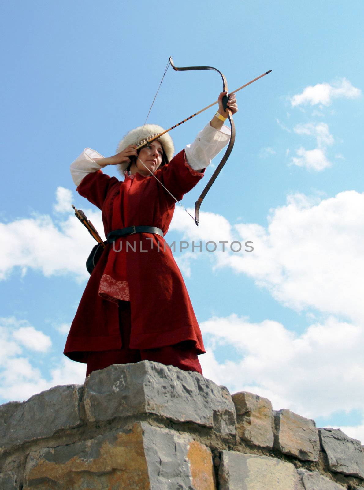 Beautiful girl with bow and arrows on blue sky background