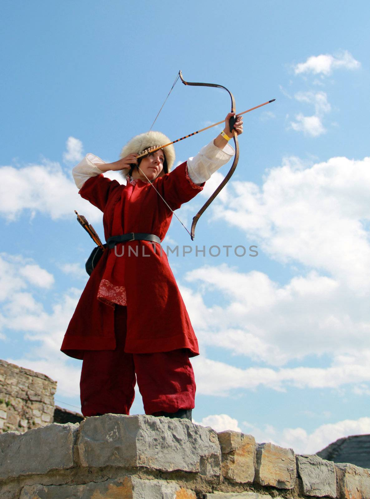 Beautiful girl with bow and arrows on blue sky background
