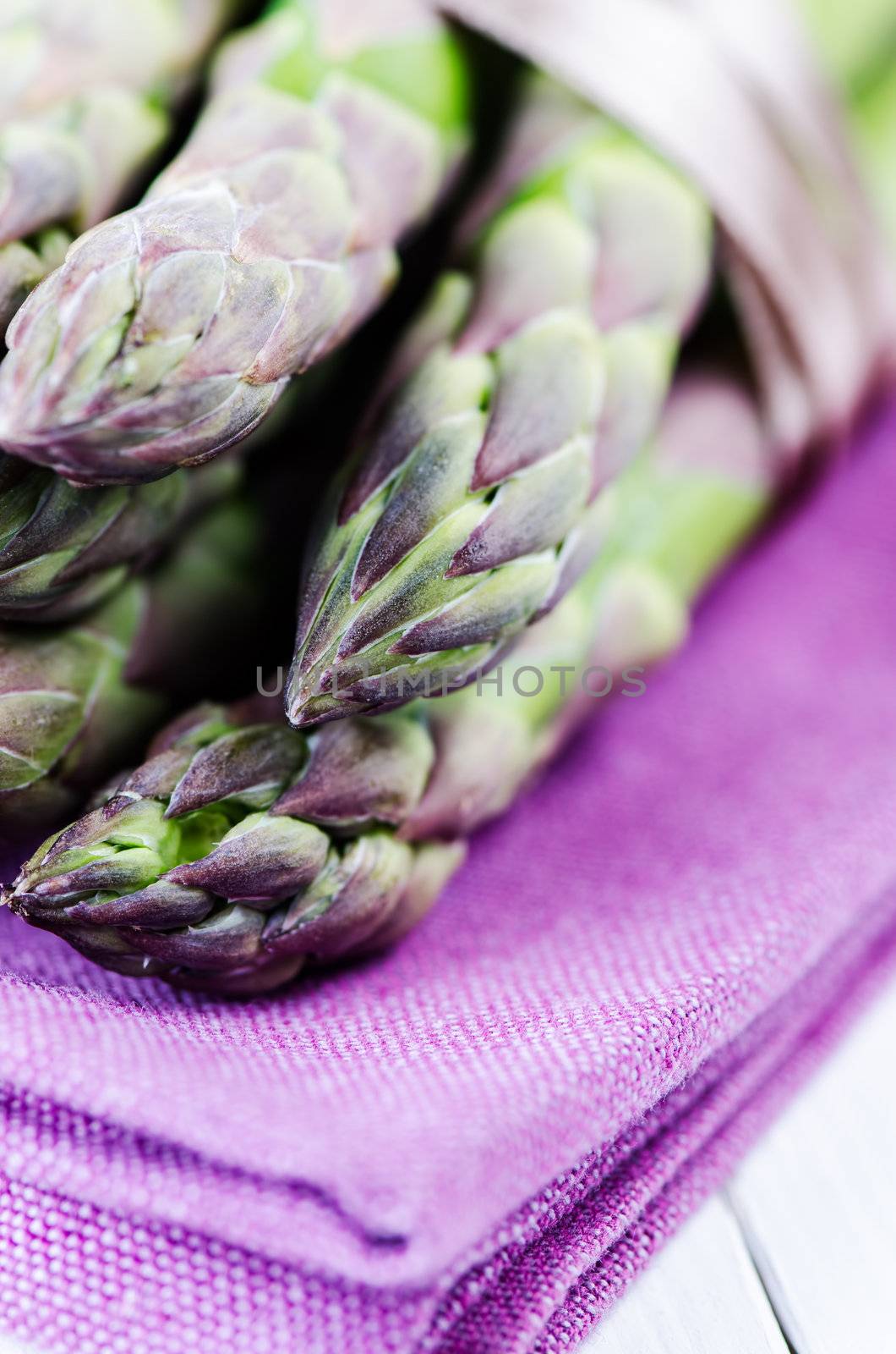 Bunch of asparagus on purple napkin close up