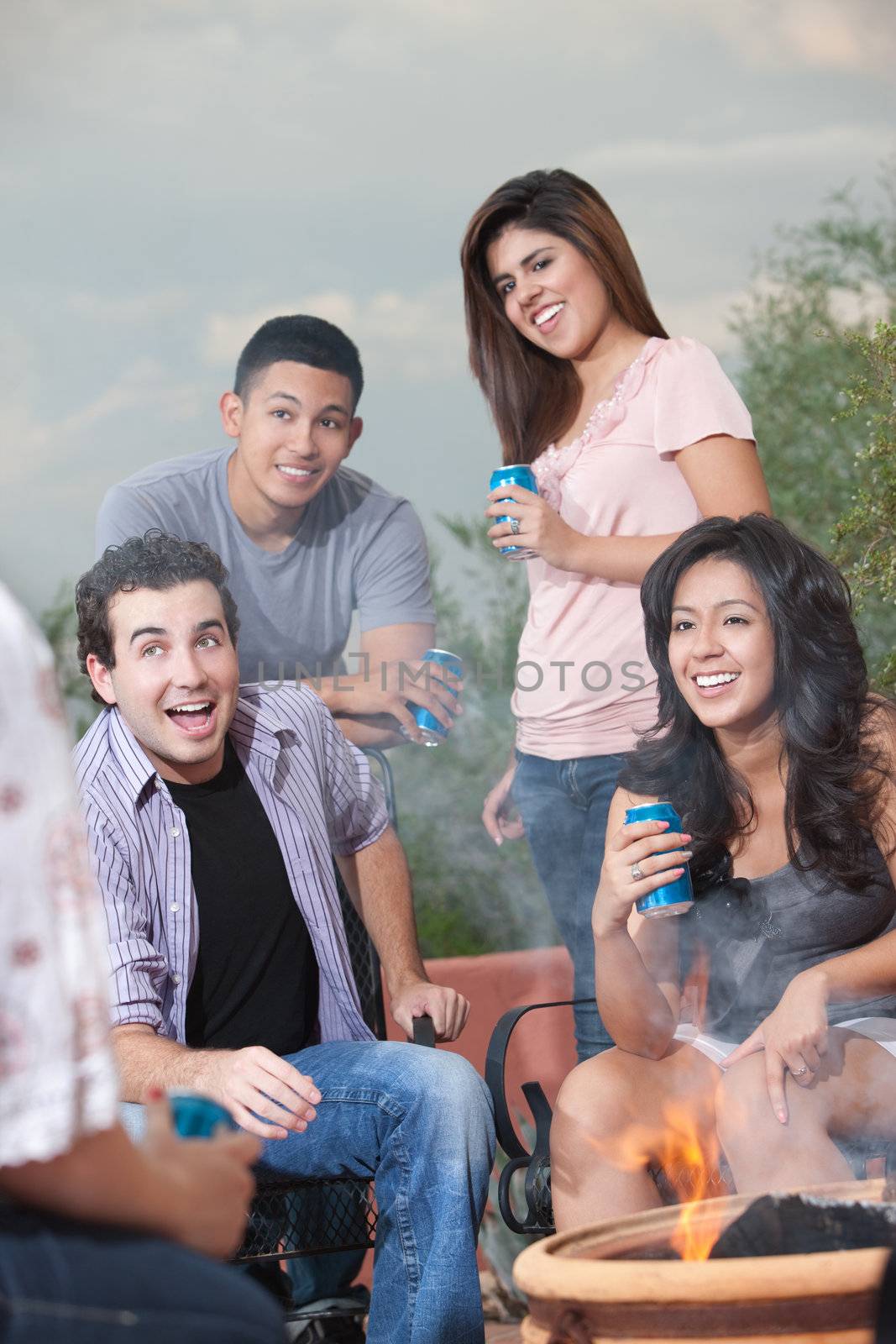 Group of teens hanging out at a barbecue drinking soda