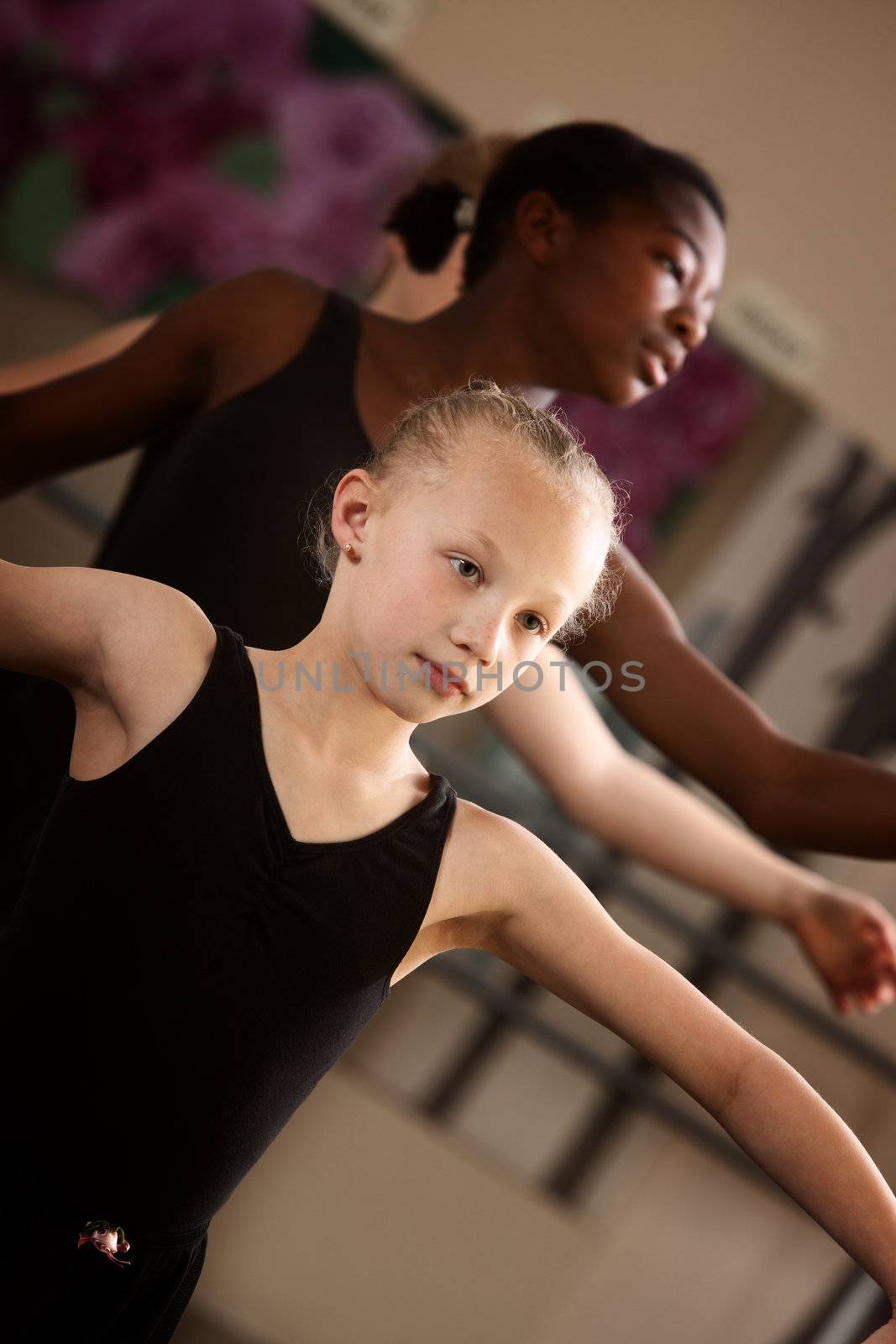 Two young ballet students concentrate in class