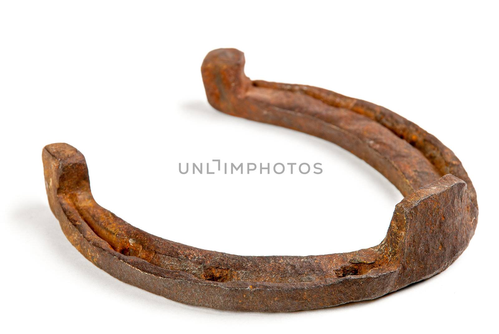 One old rusty horseshoe on a white background