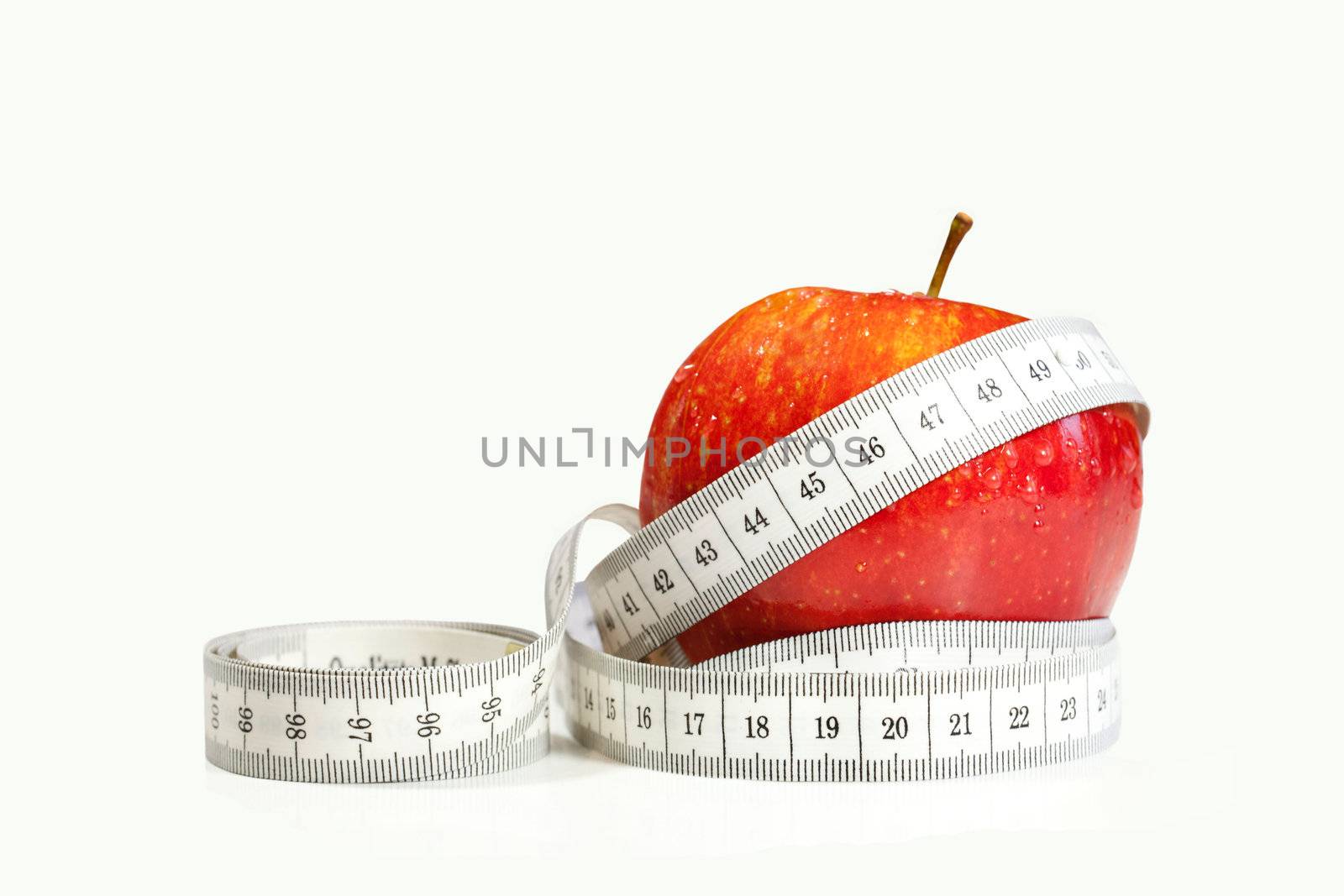 Red apple with tape measure on white background