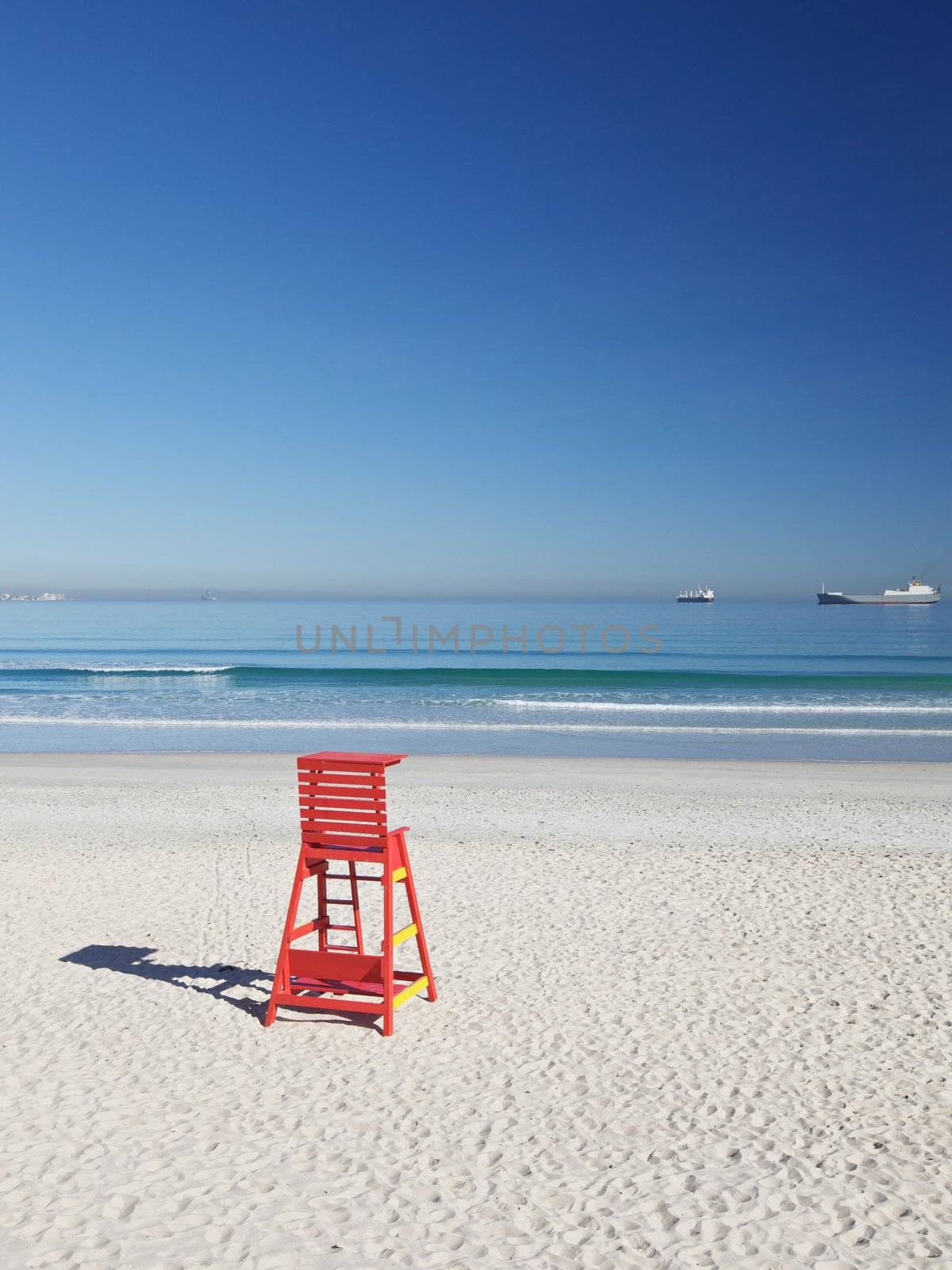 Life Saving Chair and Ships With Cargo on a Beach in Cape Town
