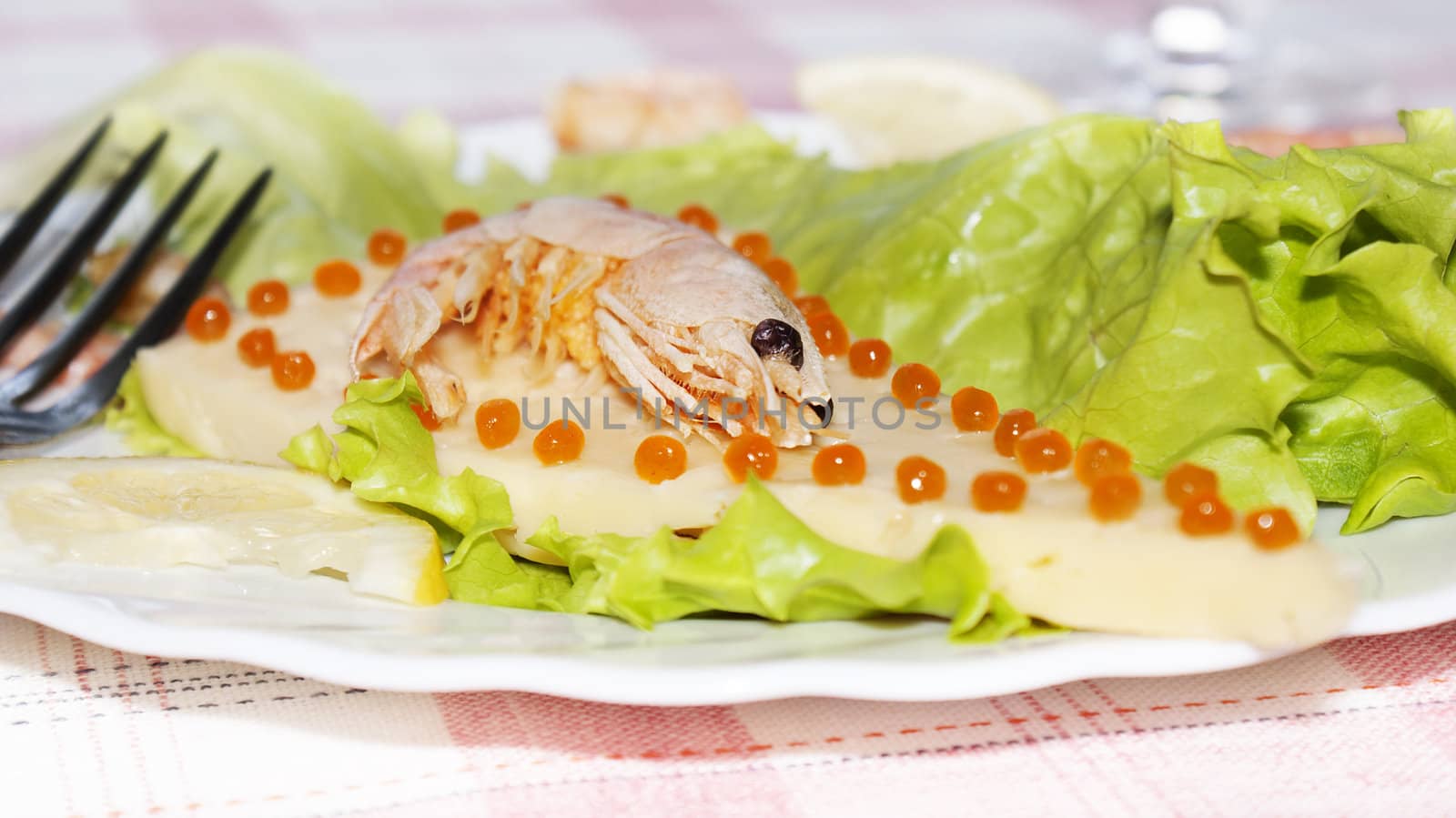 Sea shrimp on cheese with red caviar of a salmon and leaves of green salad.  Restaurant background