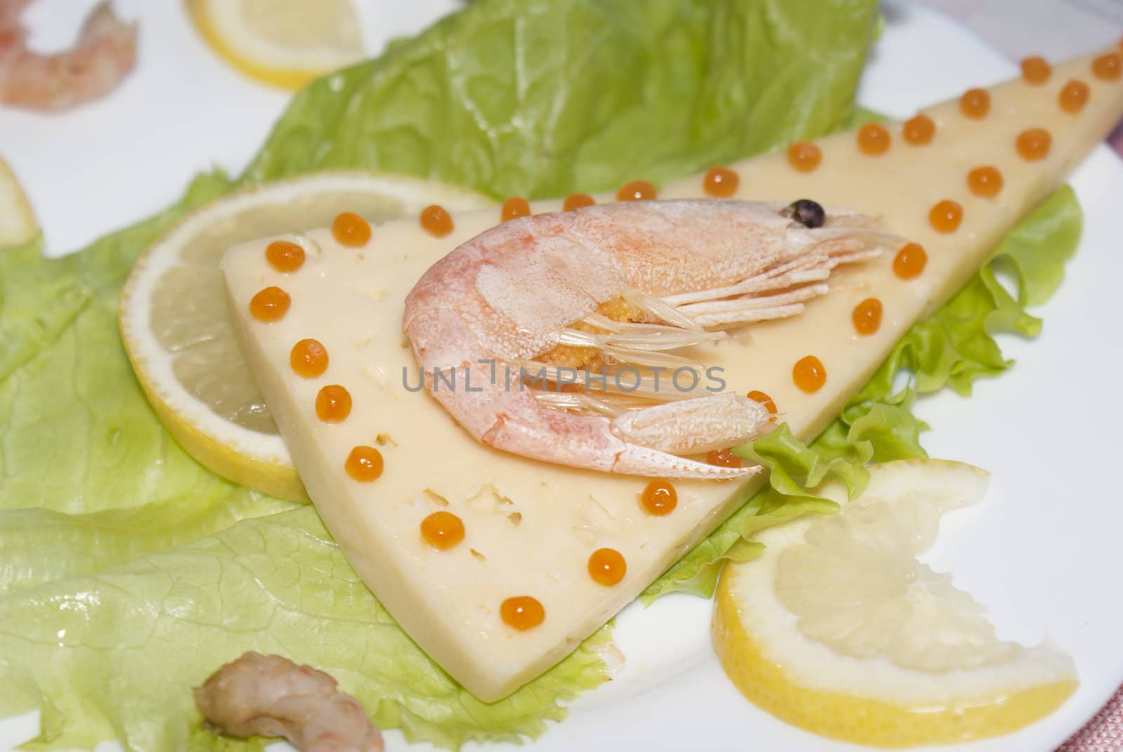 Sea shrimp on cheese with red caviar of a salmon and leaves of green salad.   Restaurant business