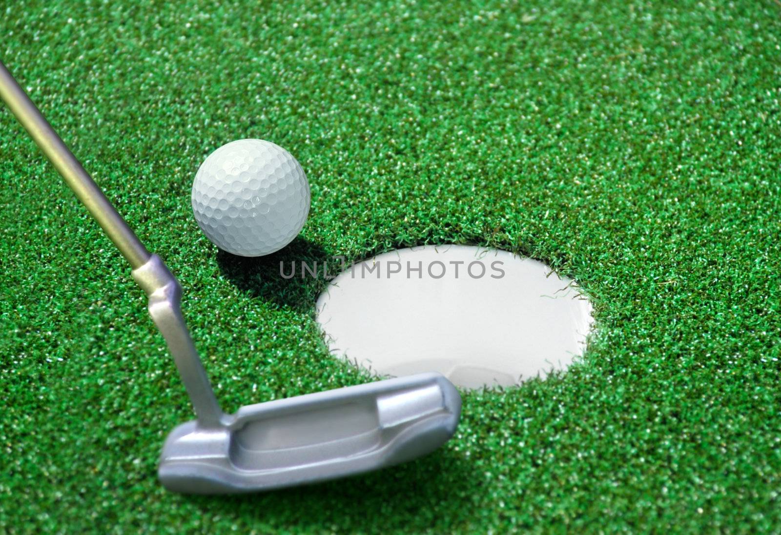 golf ball and tee on green course in front of driver