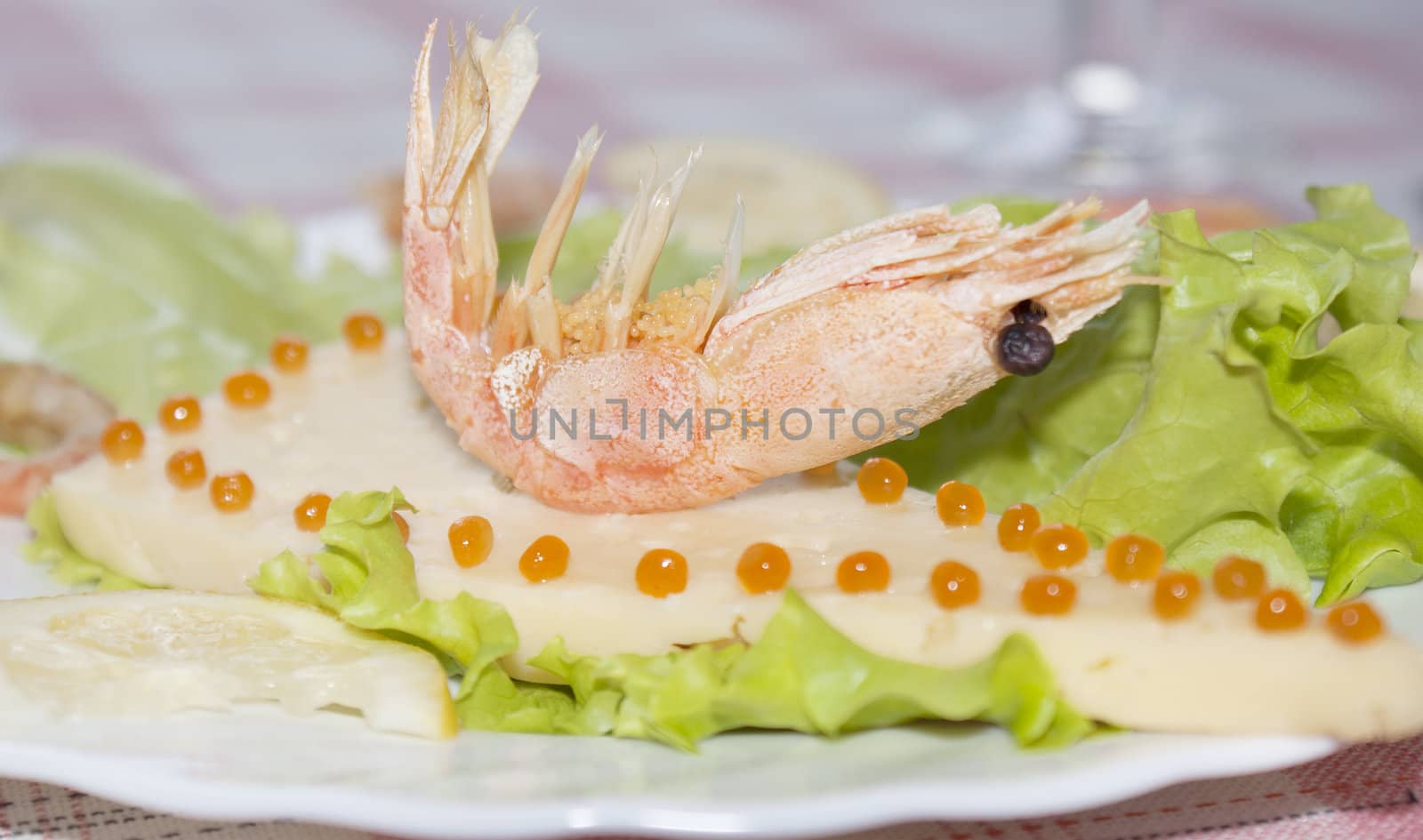 Sea shrimp on cheese with red caviar of a salmon and leaves of green salad