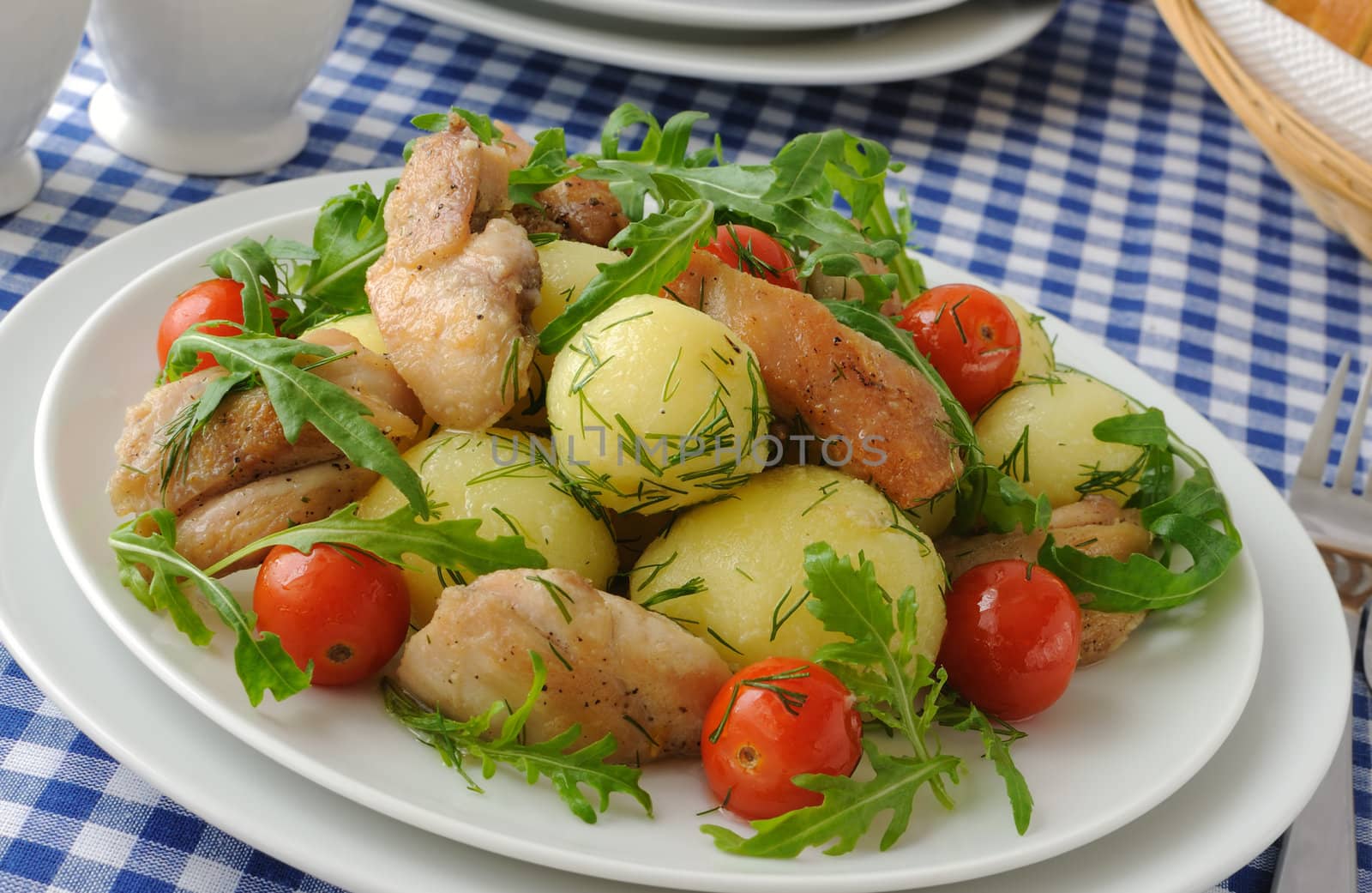 Boiled potatoes with chicken, arugula and tomato