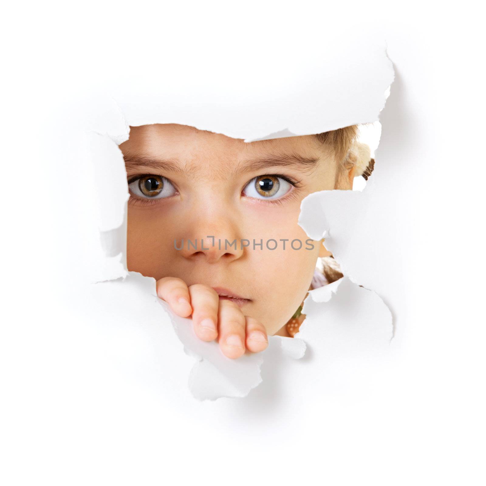 Face of the child looking through a hole in the white paper