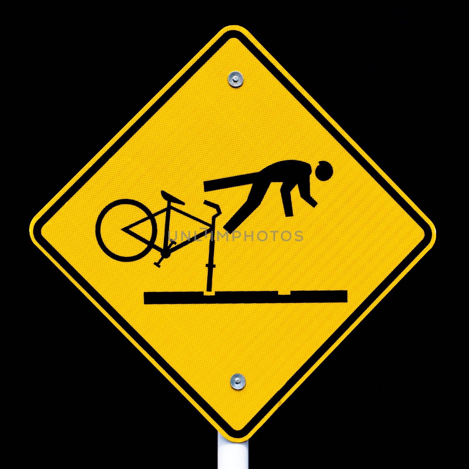 Road sign warning cyclists of dangerous tram tracks isolated on black background.