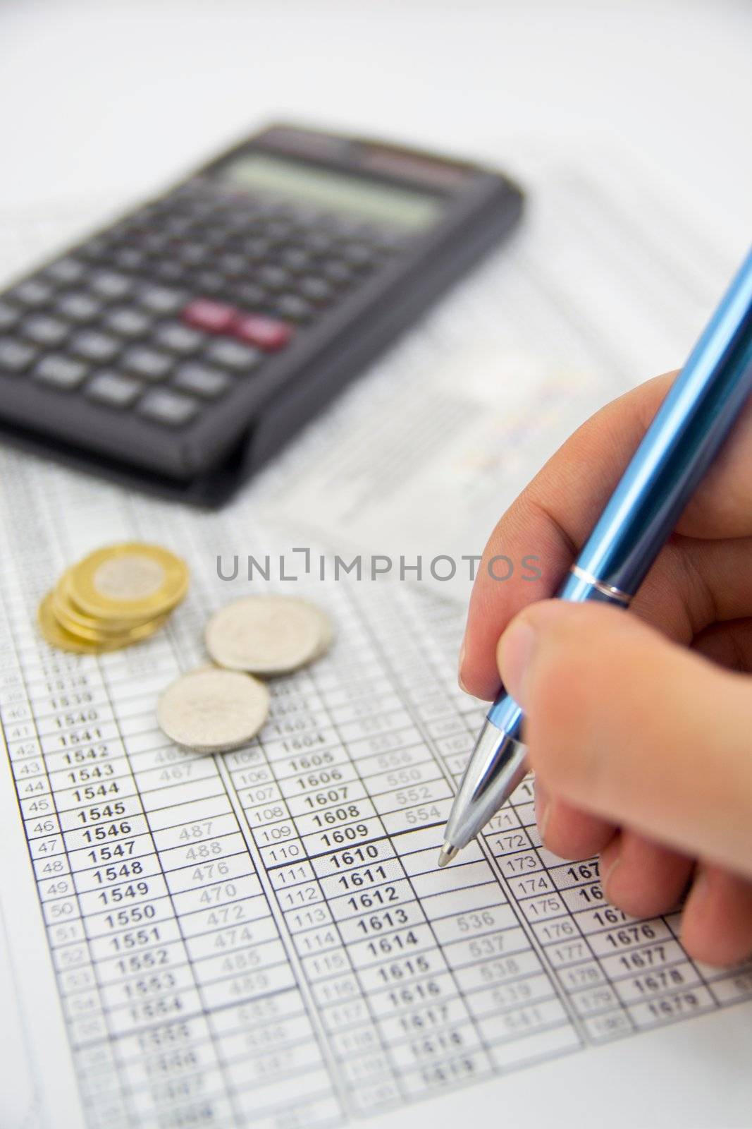 Calculator, coins and pen on a business background