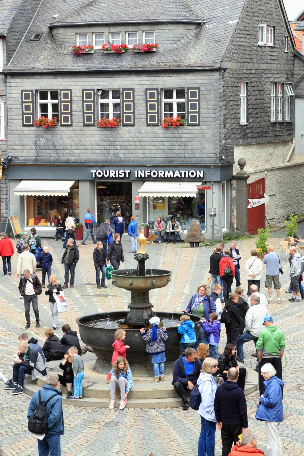 GOSLAR, GERMANY - JULY 25:view of tourists at the market place with marktbrunnen in the old town goslar, tourist information in the background , market place June 25, 2011 in Goslar, Germany
