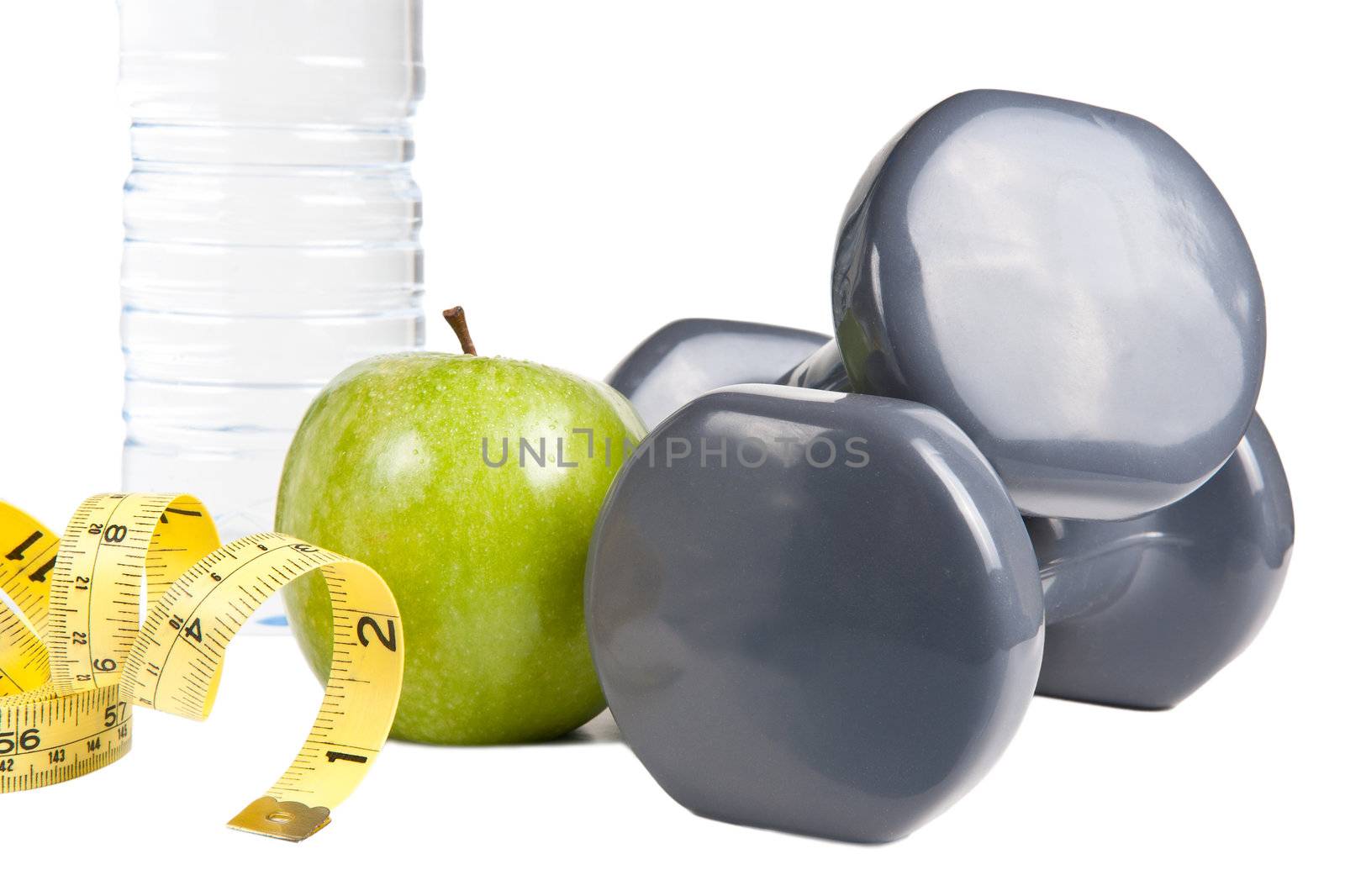 Pair of dumbbells, green apple, measuring tape and bottle of water. Exercise and healthy diet concept.