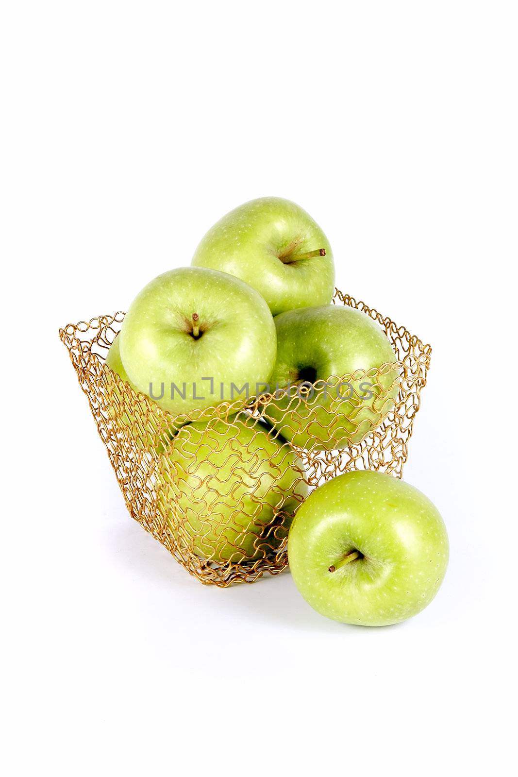 Green celebratory apples lie in a gold basket on a white background