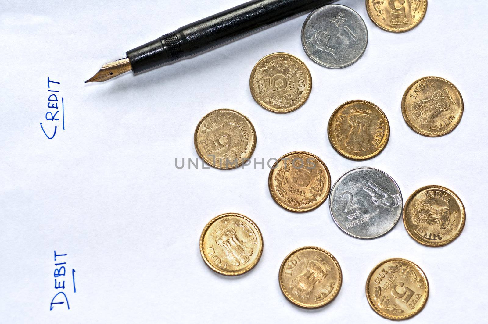 Closeup of  accounting, sheet of paper, pen and coins, debit credit columns, isolated, copy space
