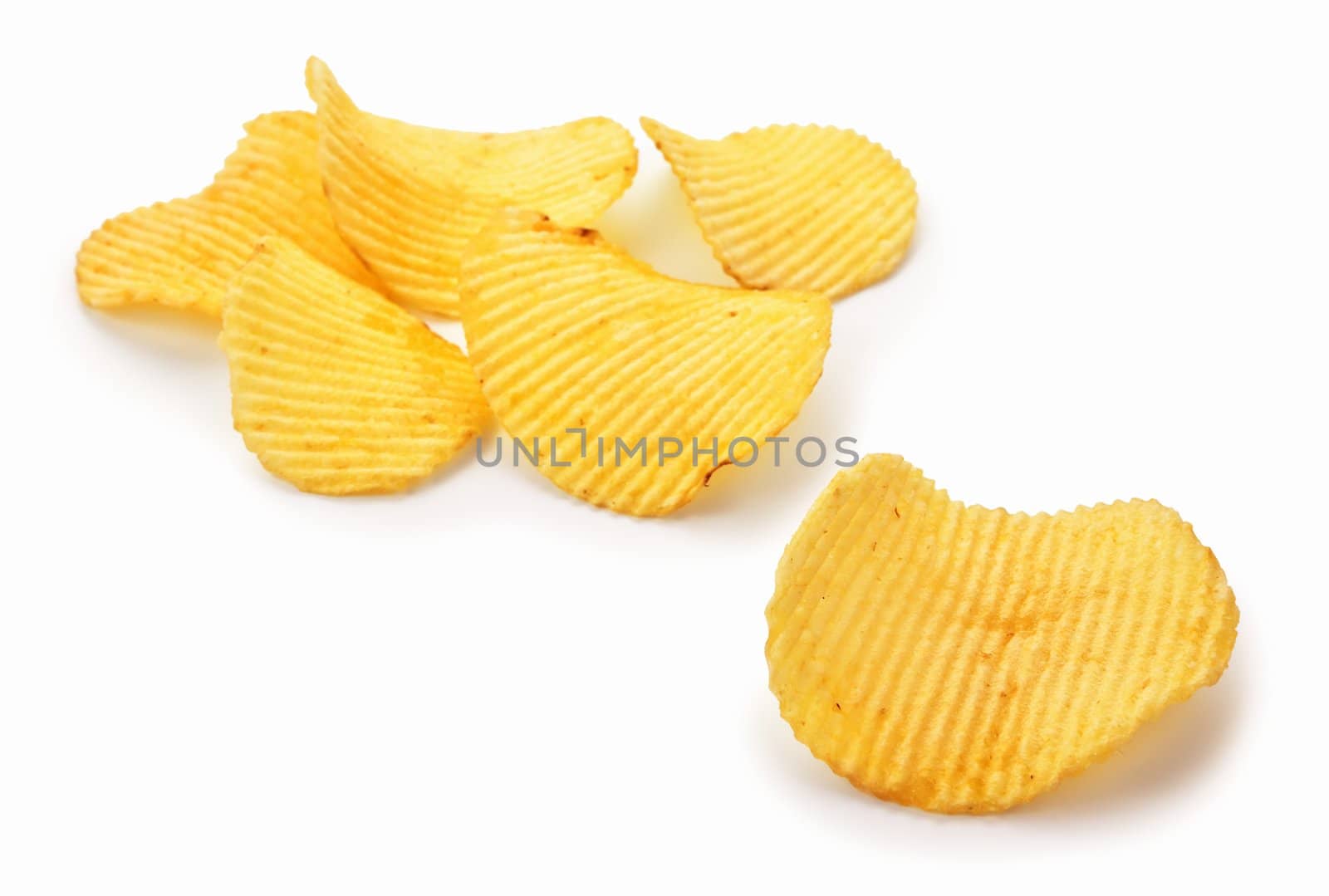 Golden potato chips on white background