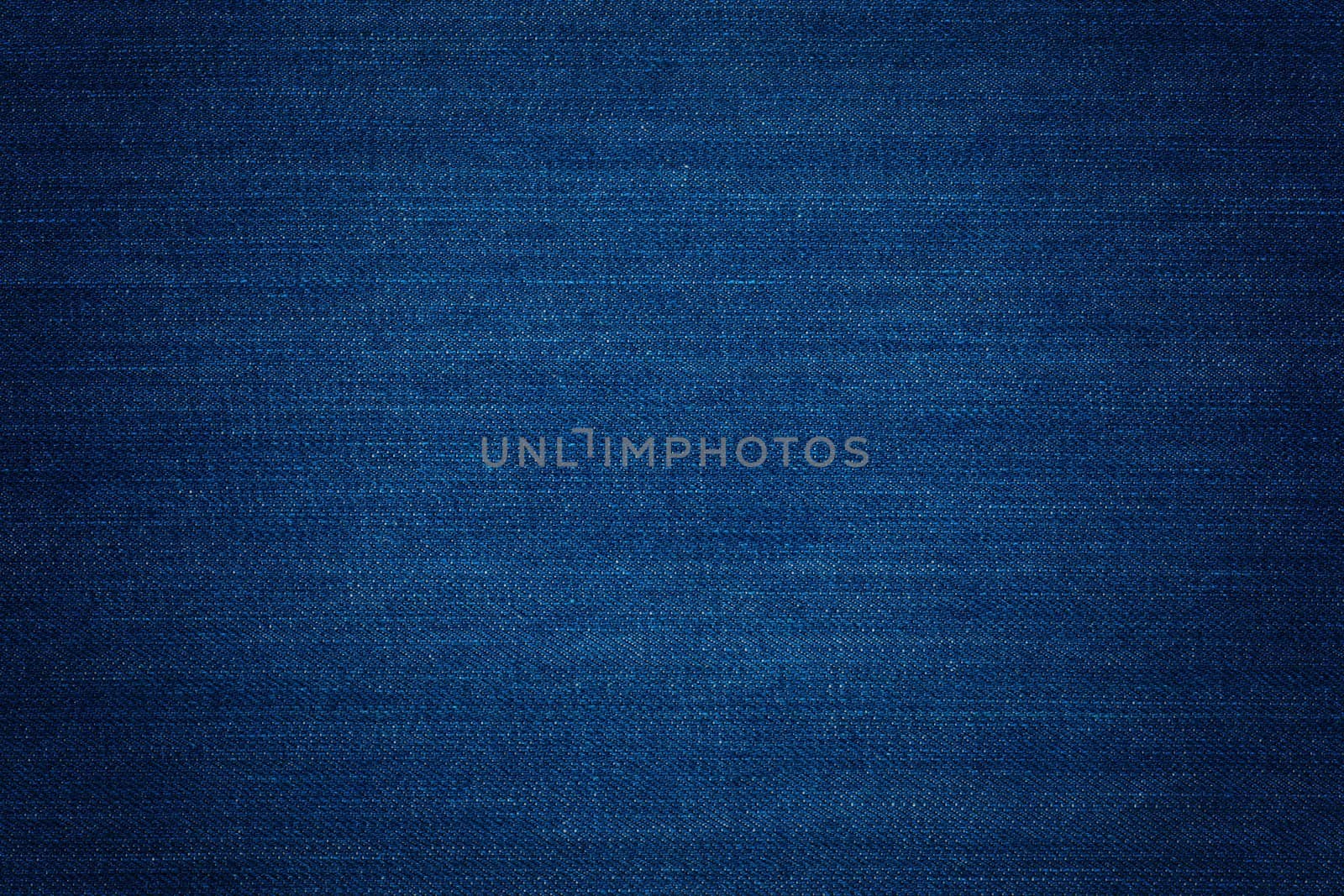 Dark blue denim background, detailed texture with vignette