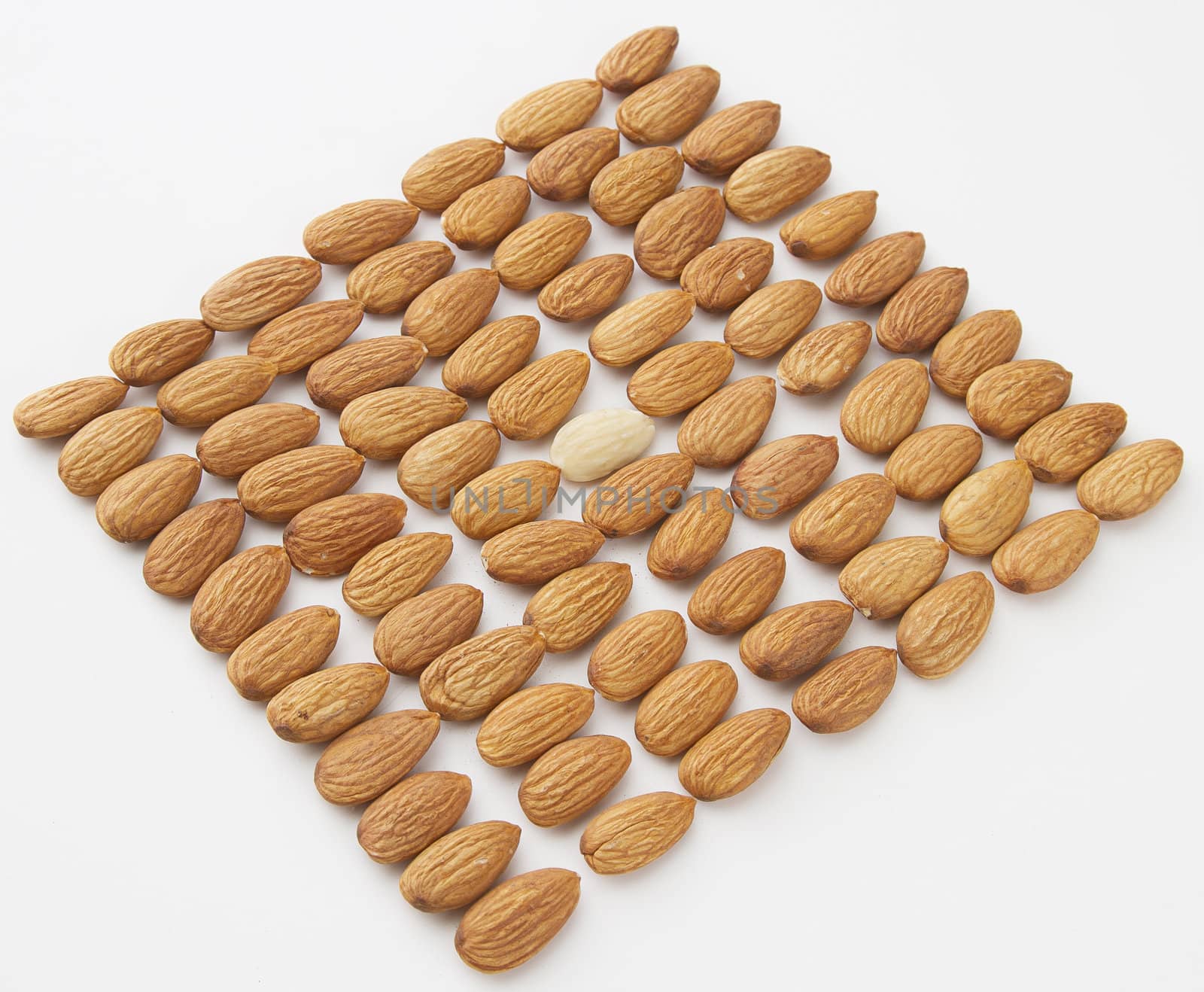 almond put in a row with one peeled almond in the middle