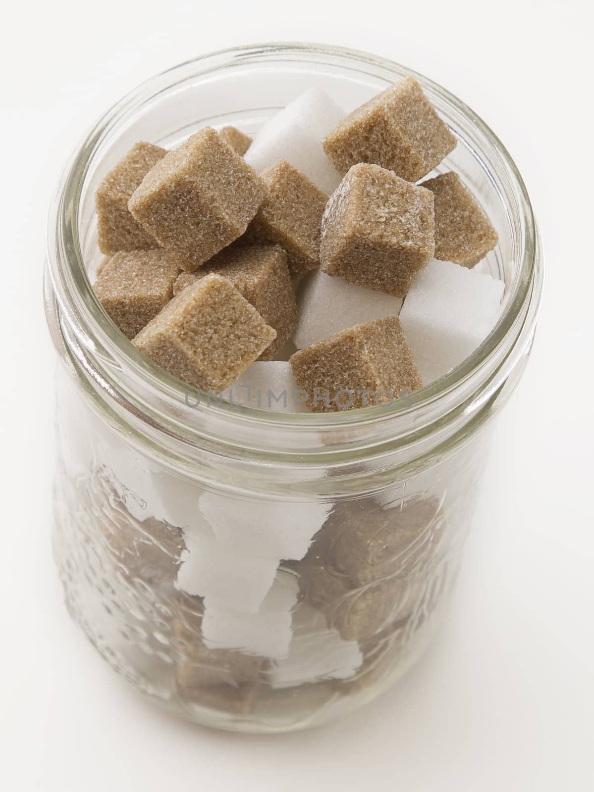 Brown and white sugar cube in a glass jar