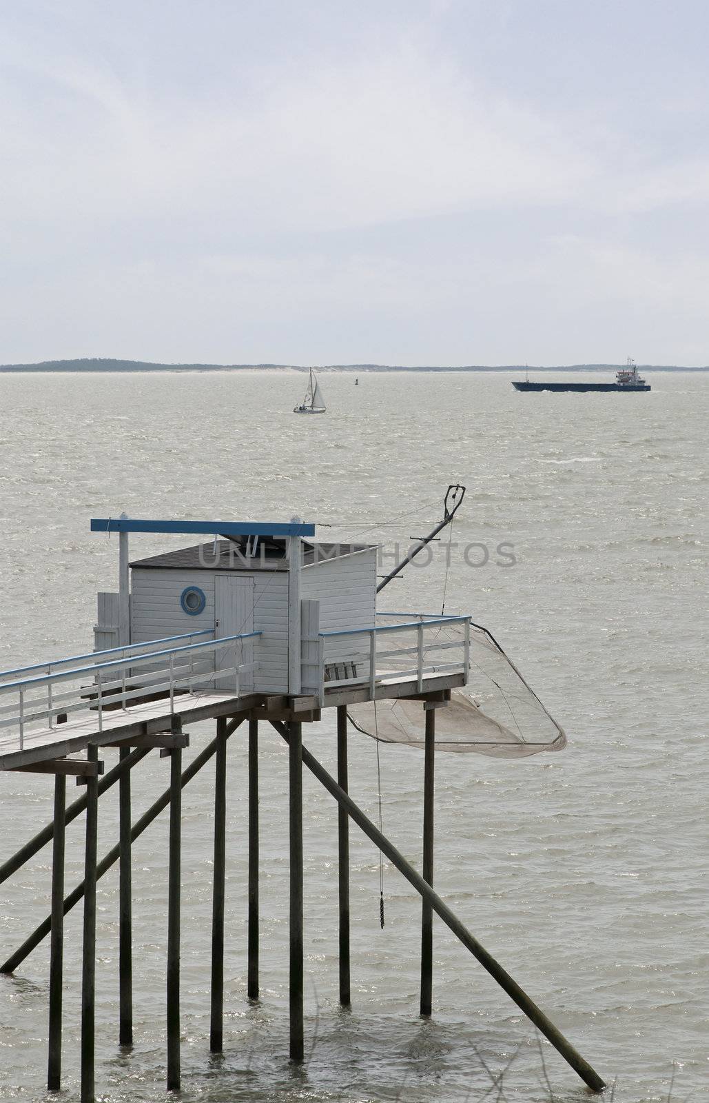 Wood Fish Hut on Piles with a Net and a Boat in Background