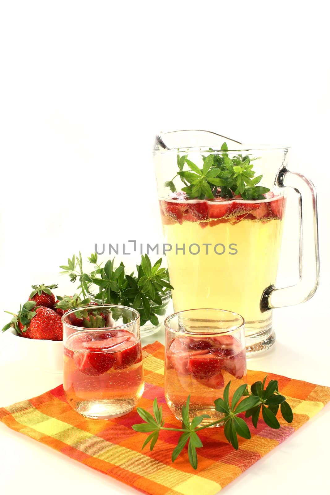 a glass of sweet woodruff punch with fresh strawberries