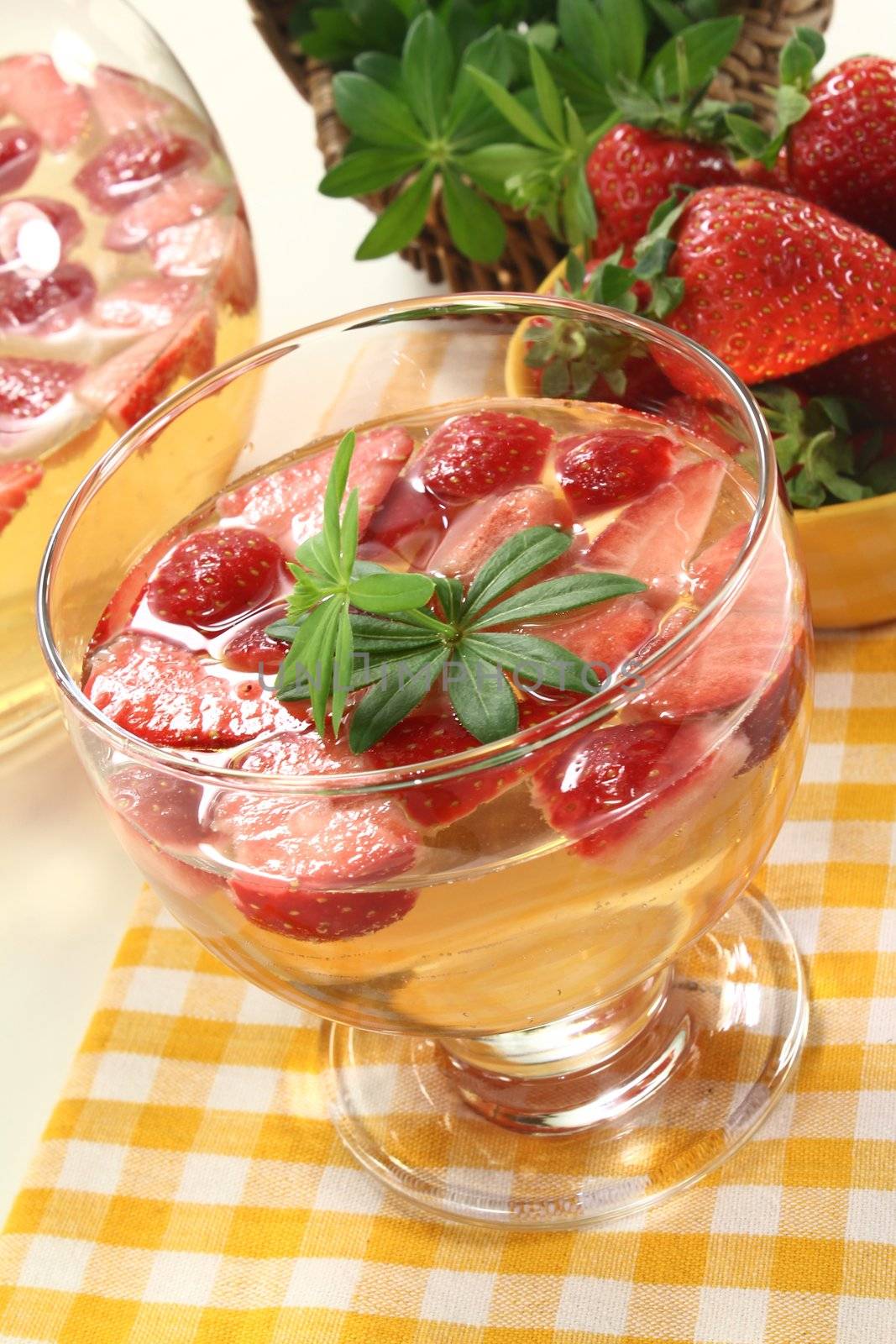 a glass of sweet woodruff punch with fresh strawberries