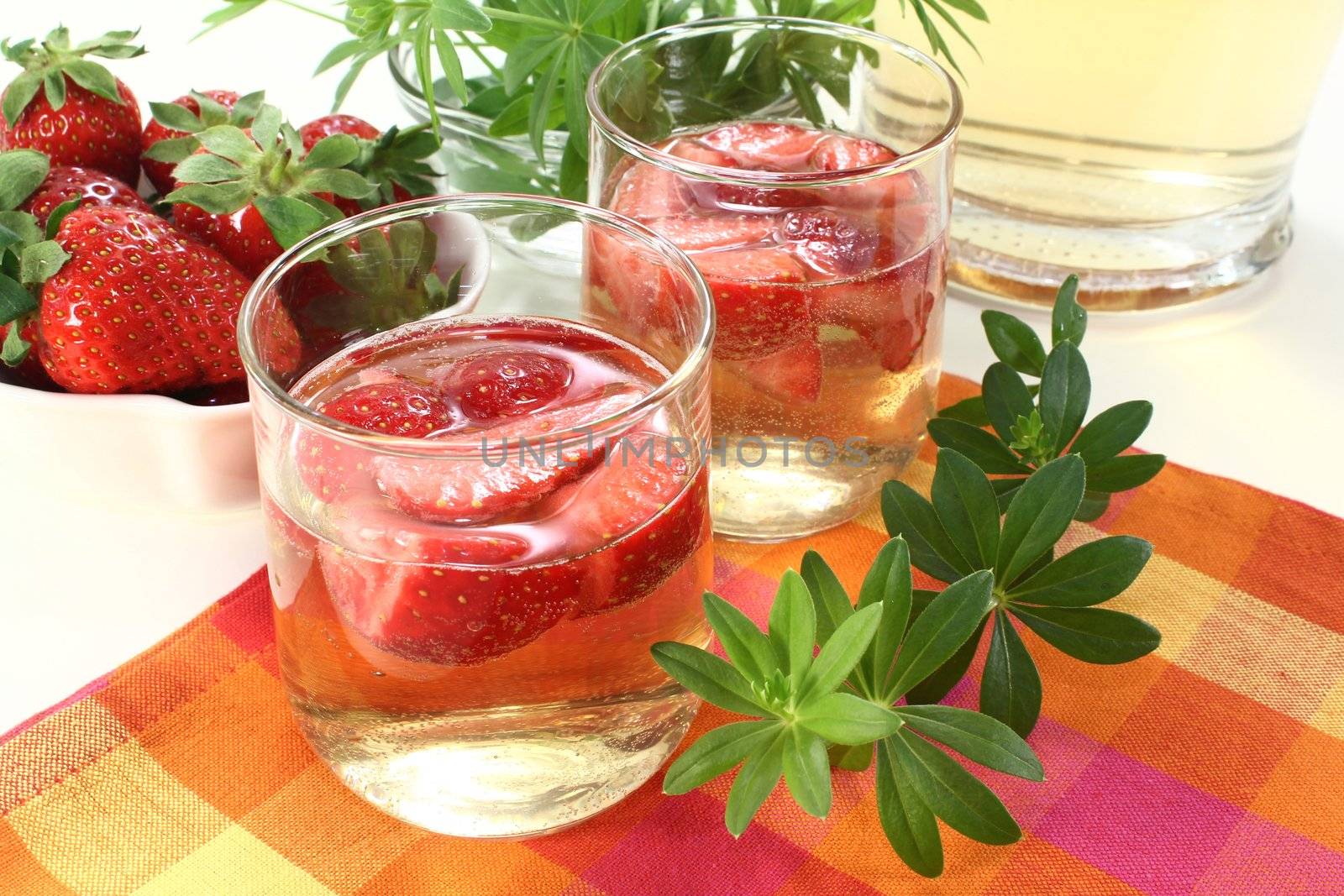 a glass of sweet woodruff punch with fresh strawberries