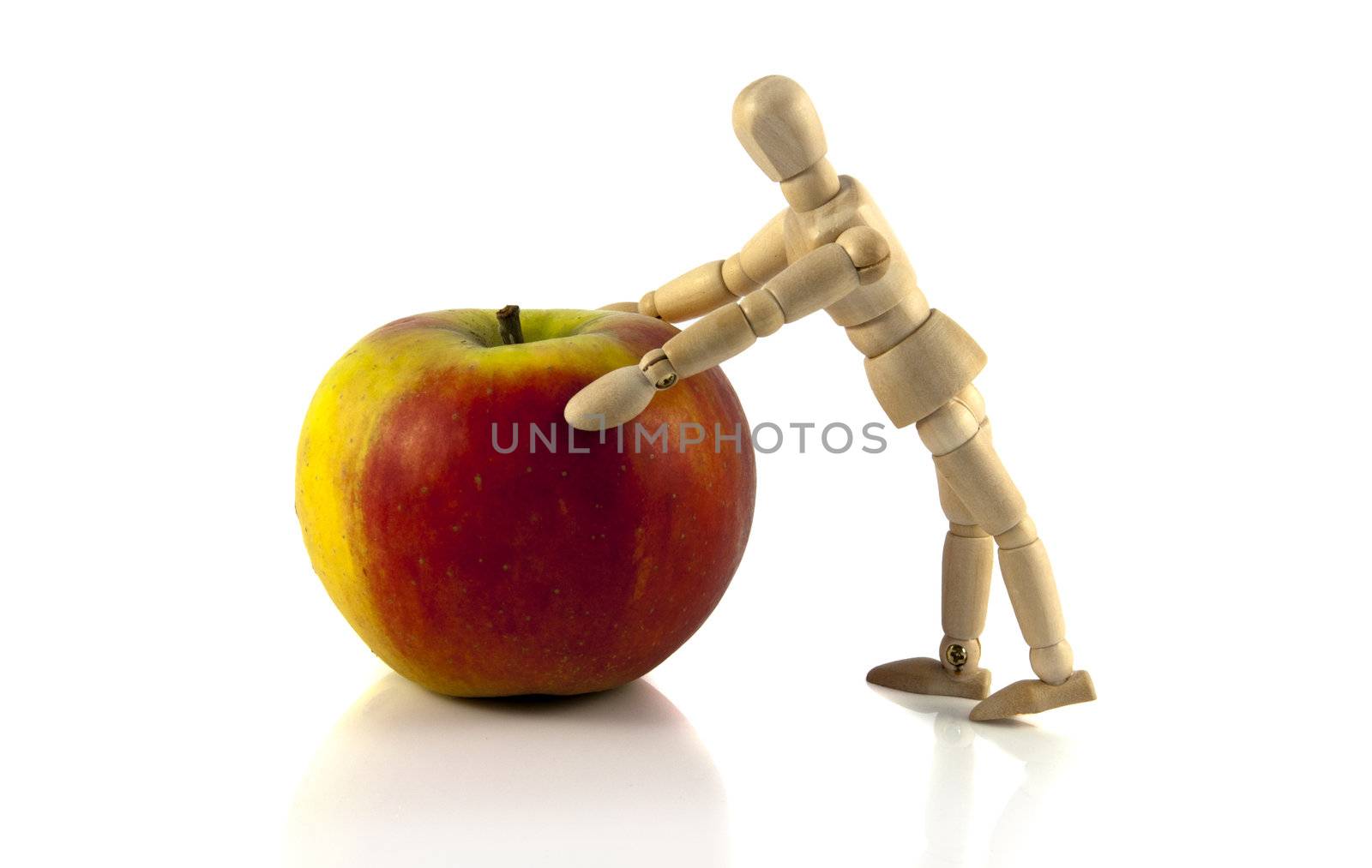 wooden male  puppet pushing the apple