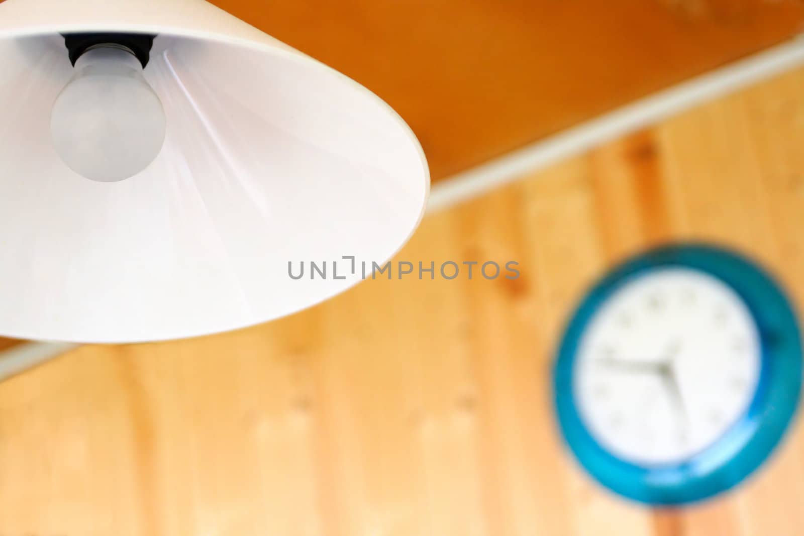 White light in the foreground and the clock in a blue body blurred in the background