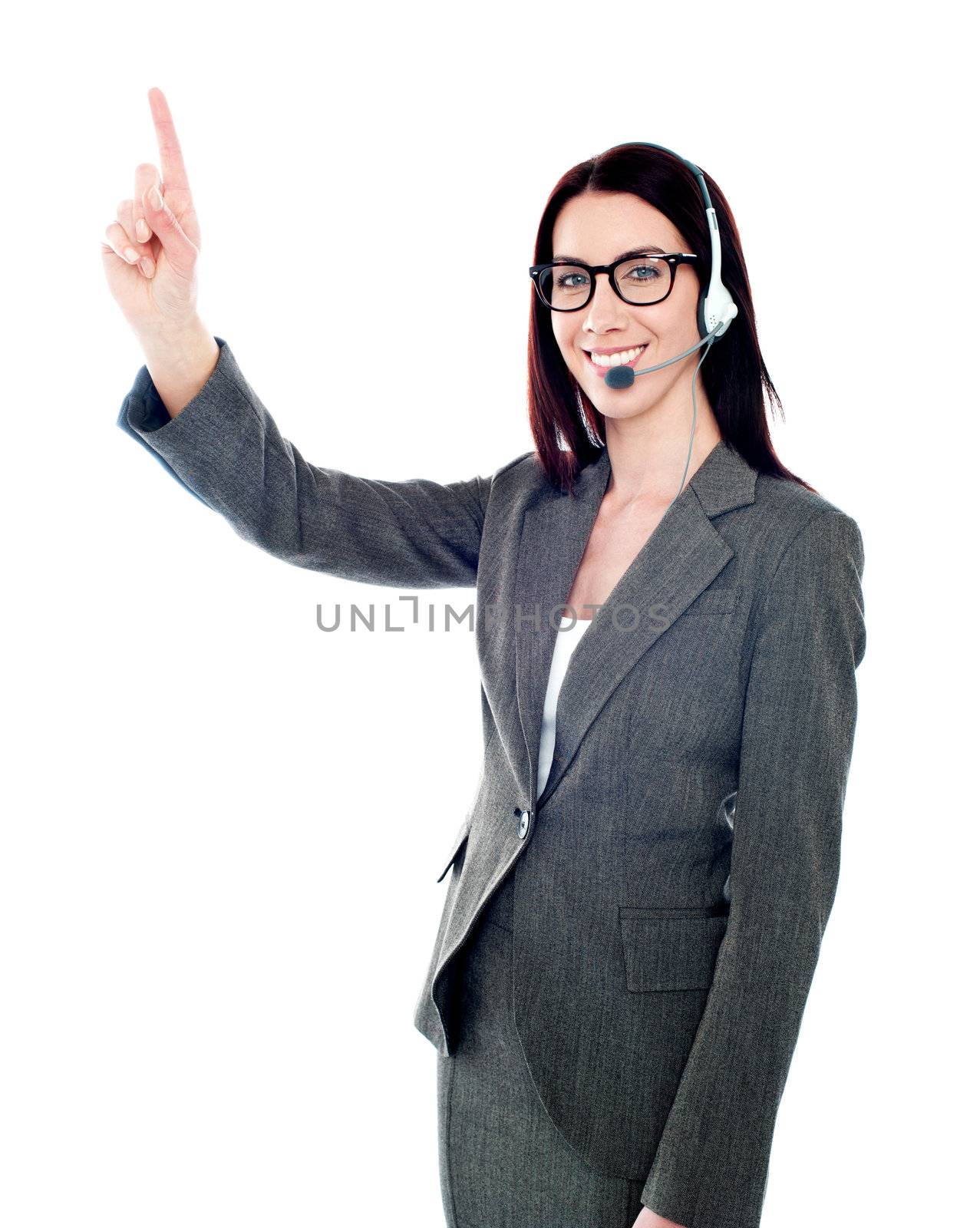 Beautiful customer care executive pointing up at copyspace over white background