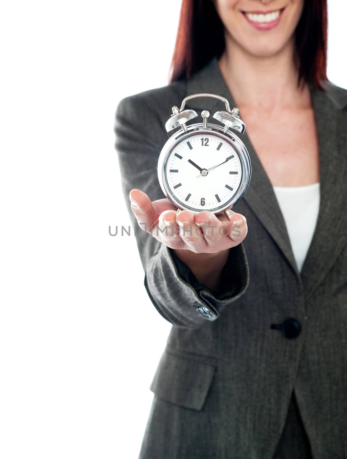 Cropped image of a woman holding alarm clock. Studio shot