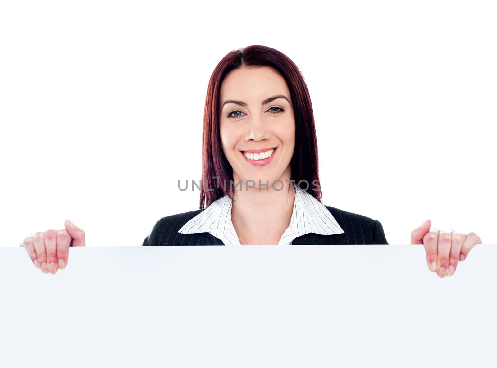 Young smiling beautiful woman standing behind blank white billboard