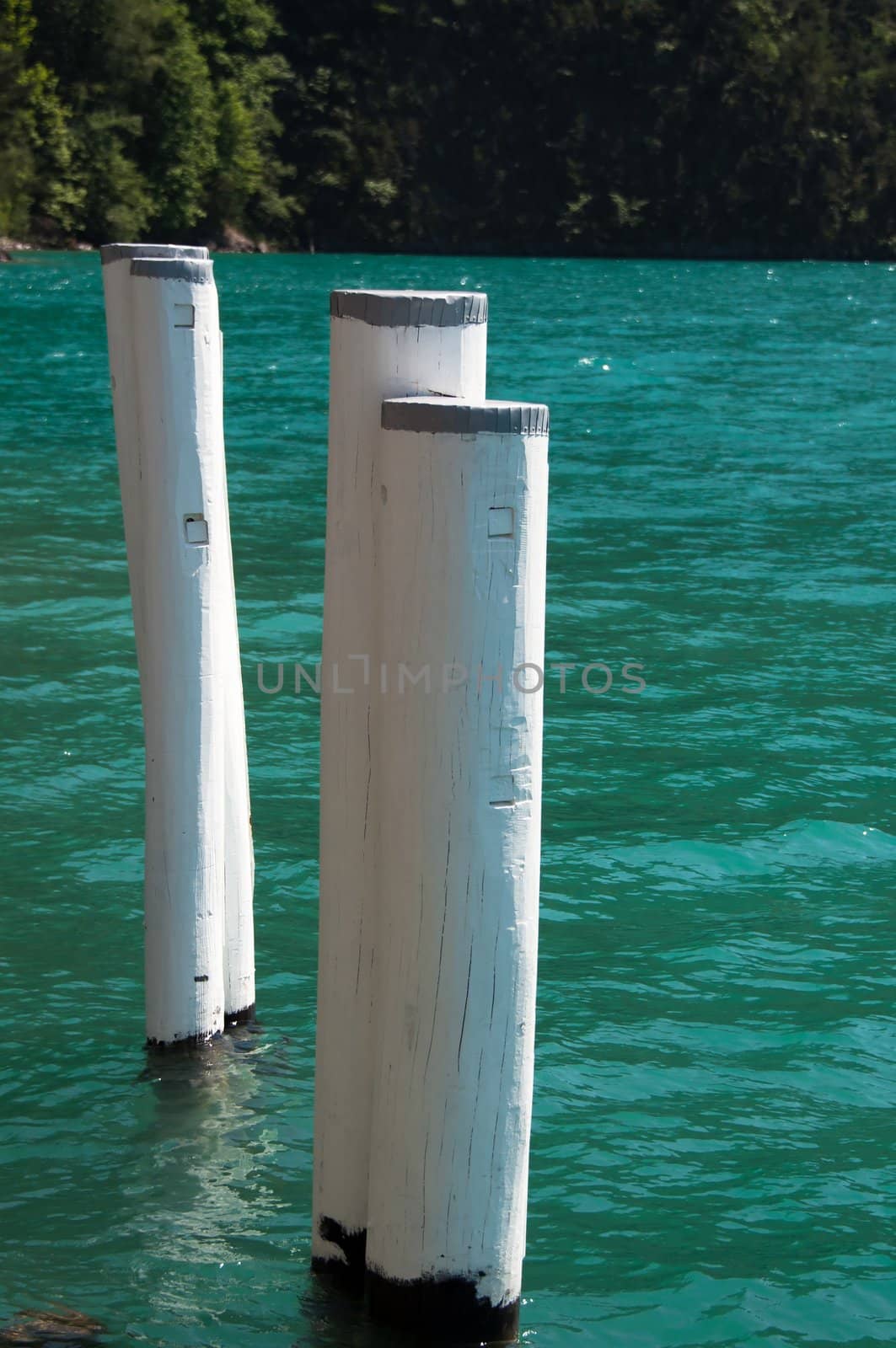 Old weathered bollard in great blue water at Lake Luzerne, Switzerland