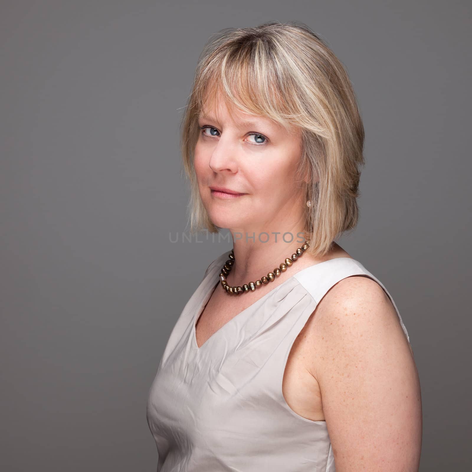 Portrait of Attractive Mature Woman with Intense Look on Grey Background