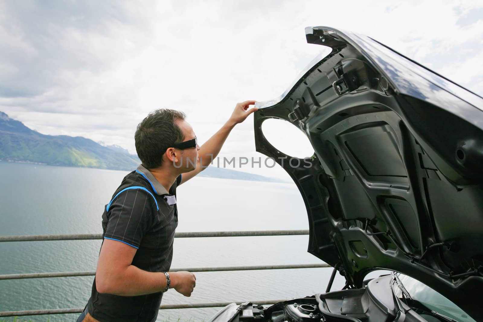 man having a bad day checks his car to figure out what the problem is.