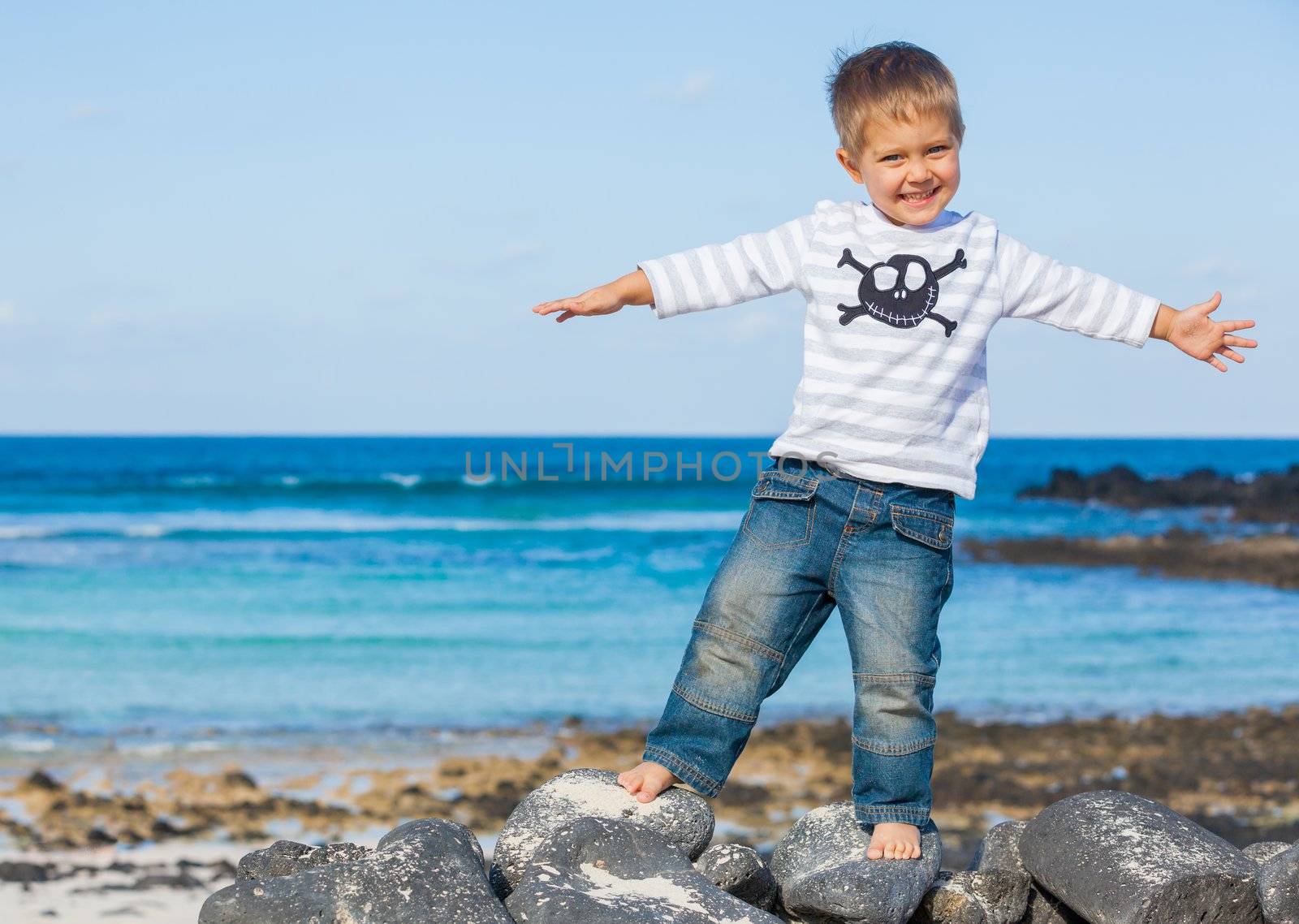 Cute boy dressed as pirate on tropical beach