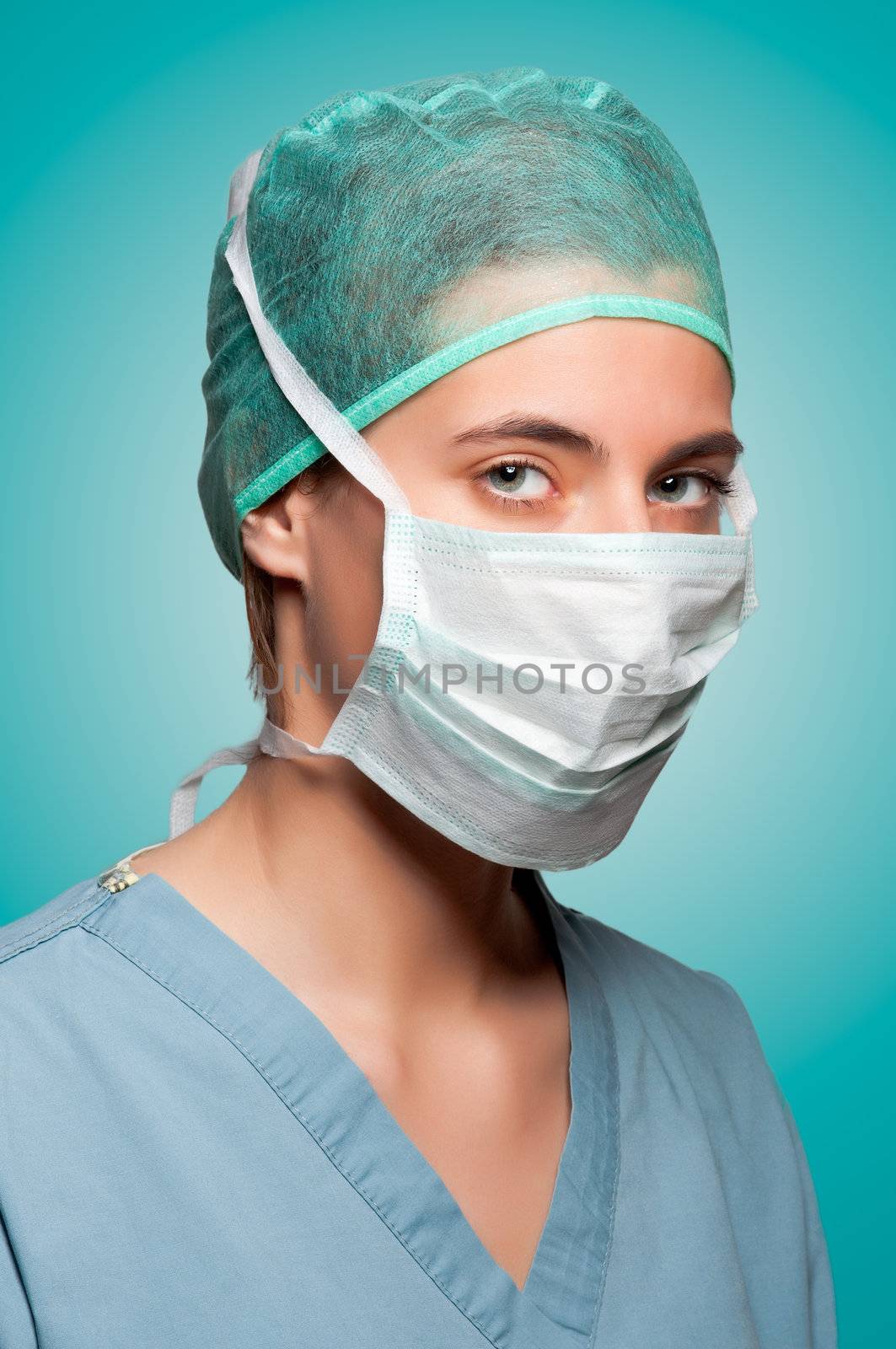 Closeup portrait of a female surgeon, with face mask, in a green background
