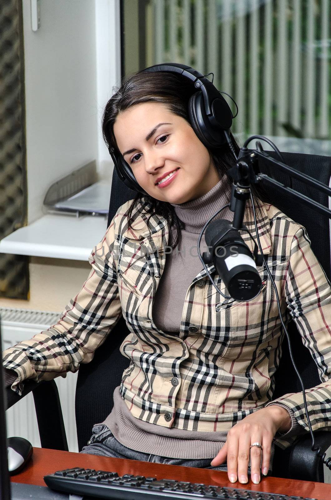 Anchorwoman in front of a microphone on the radio