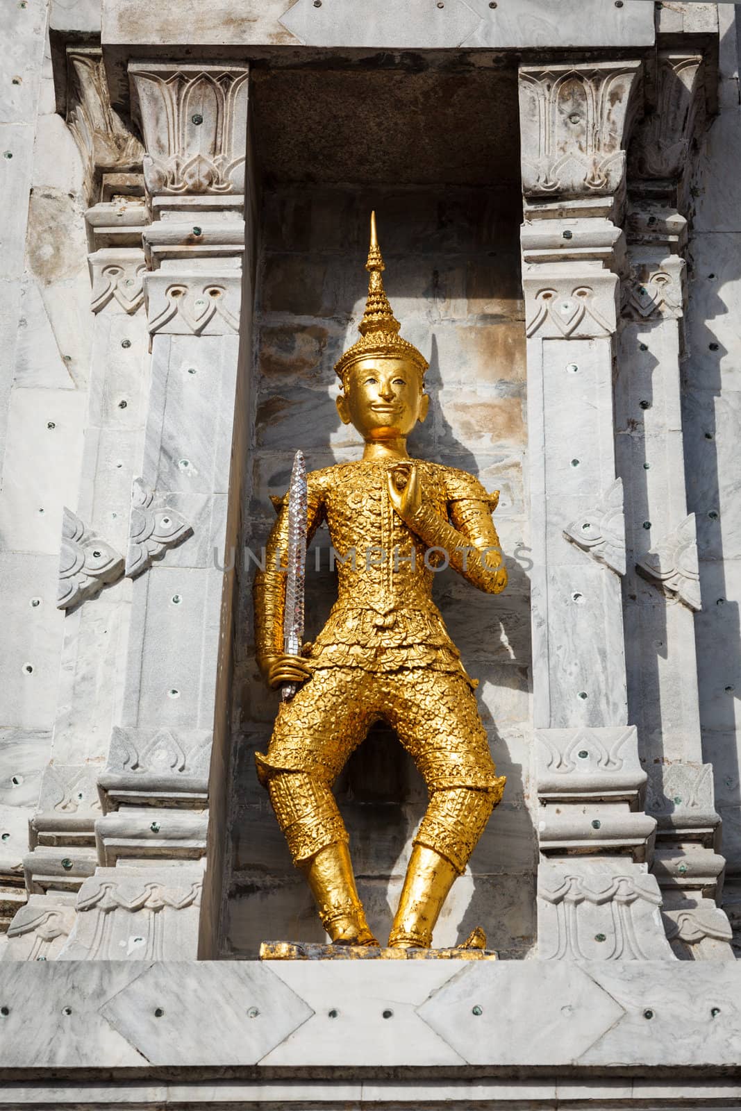Gold guard on tower, in buddhist temple Wat Phi, Bangkok, Thailand