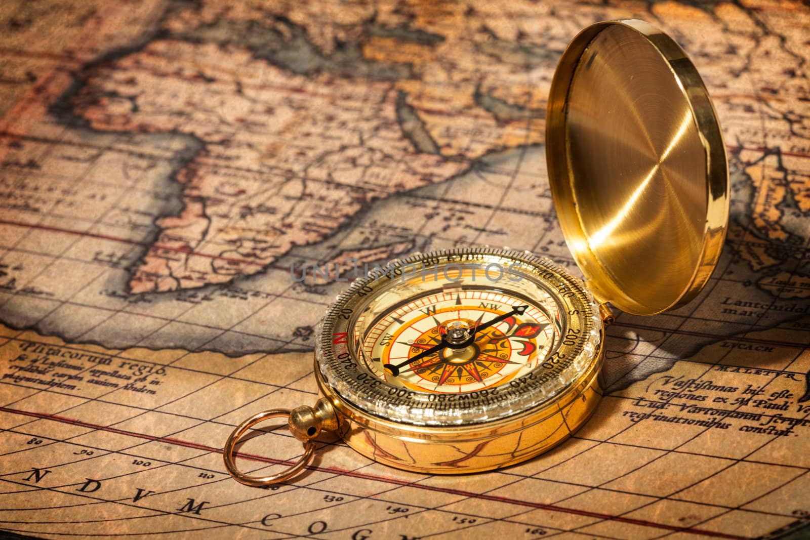 Old vintage retro golden compass on ancient map