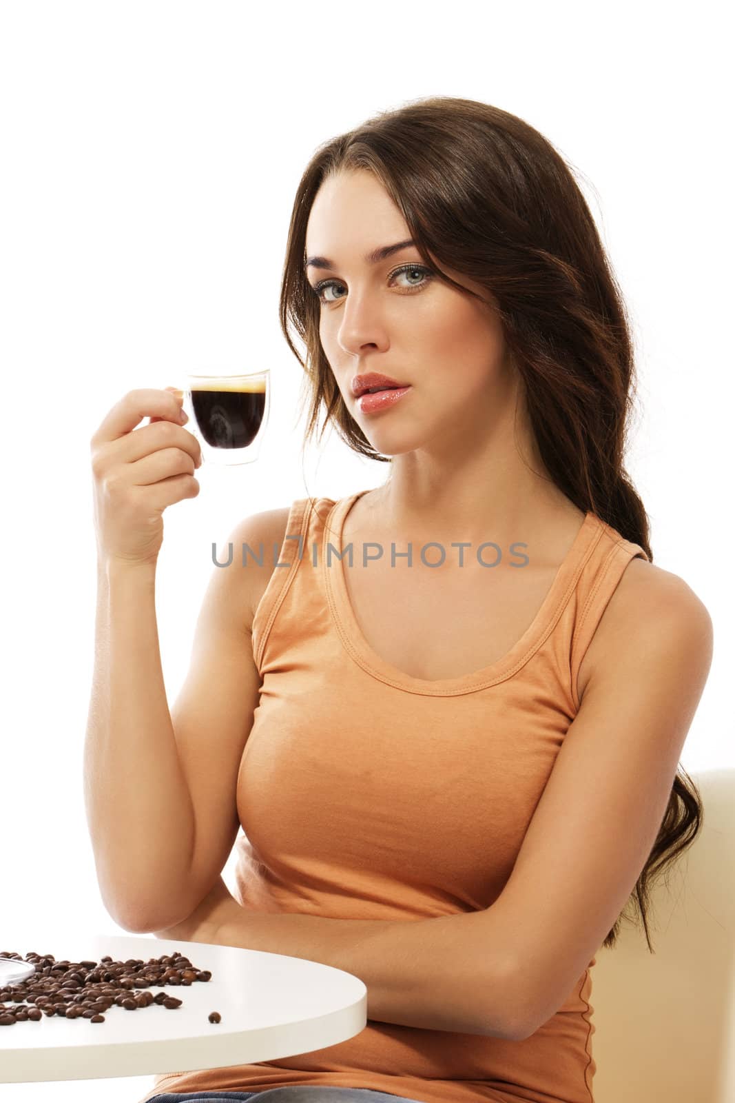 elegant young woman sitting at a table with espresso coffee on white background