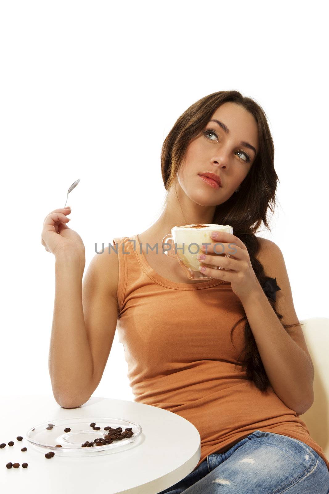 dreaming woman with cappuccino coffee sitting at a table on white background